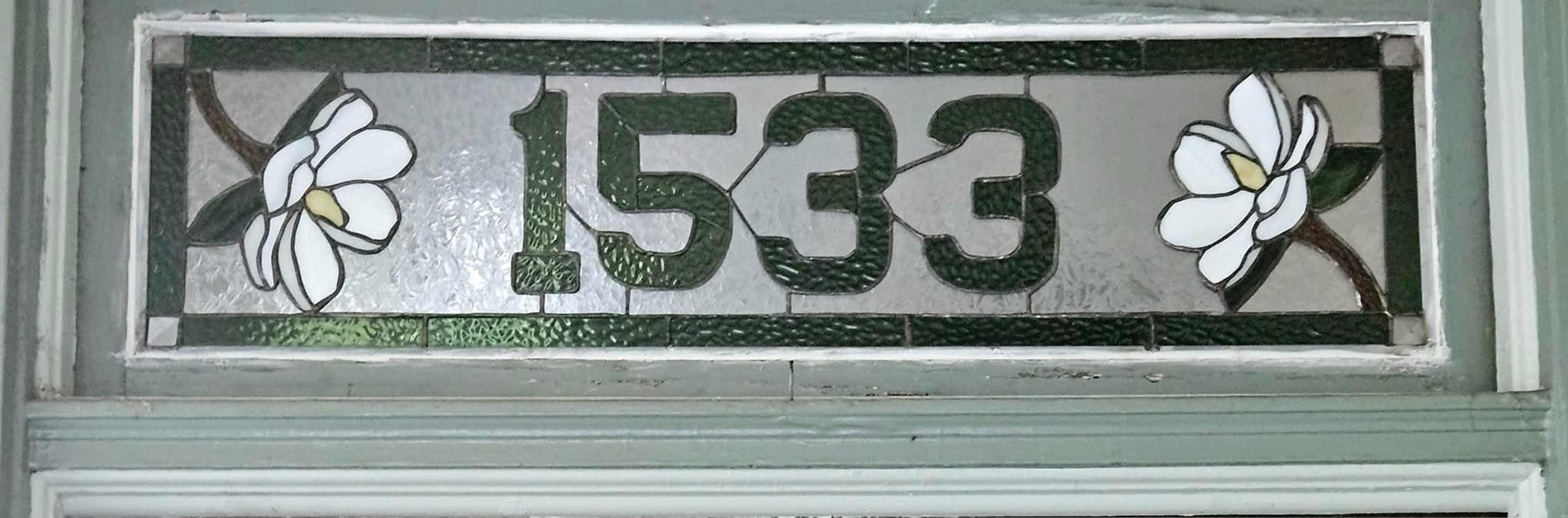 The image shows a decorative glass panel featuring the numbers "1533" intertwined with floral designs.