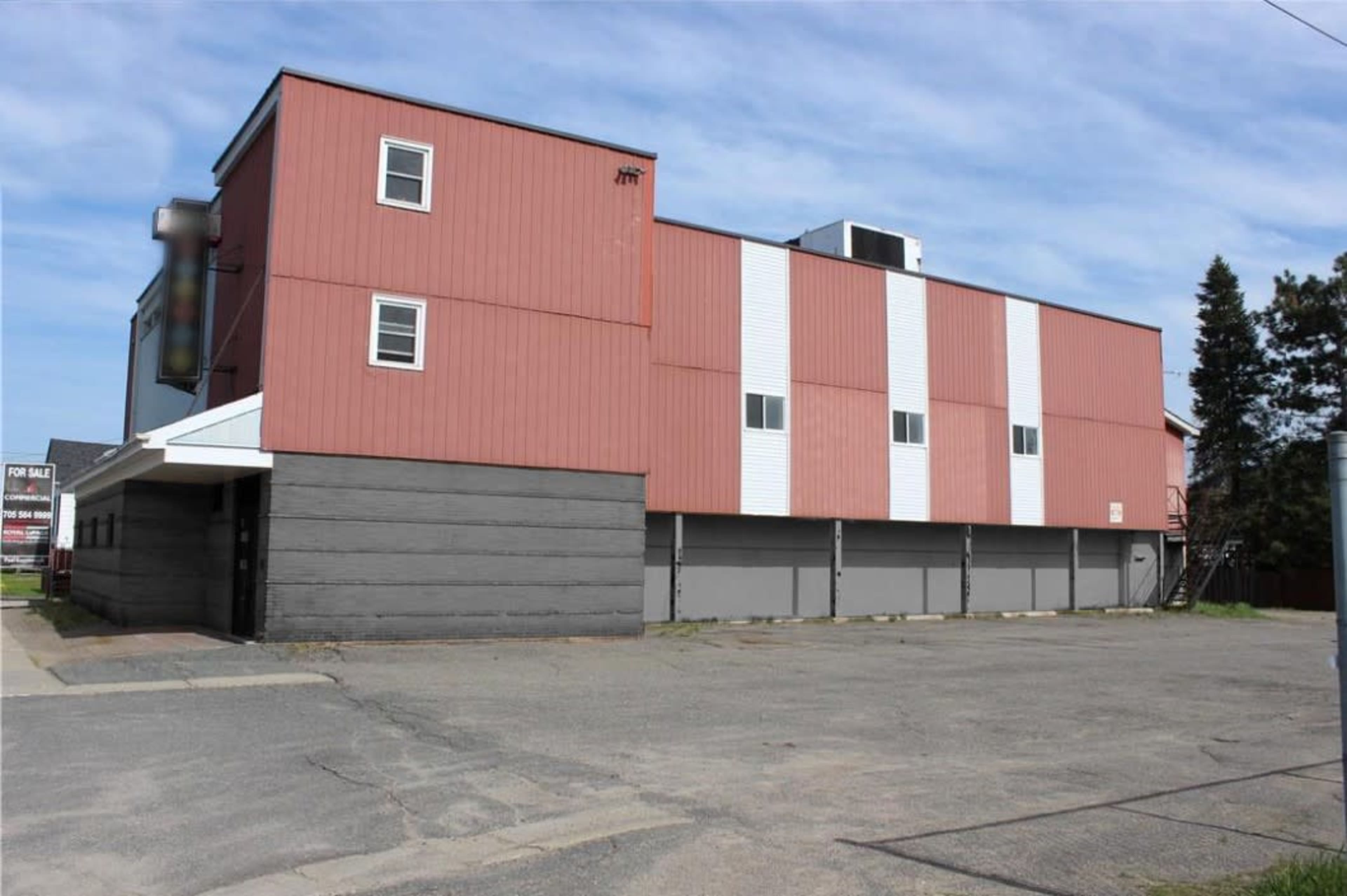 A large, two-story building with a red and white exterior, located in an empty paved area.