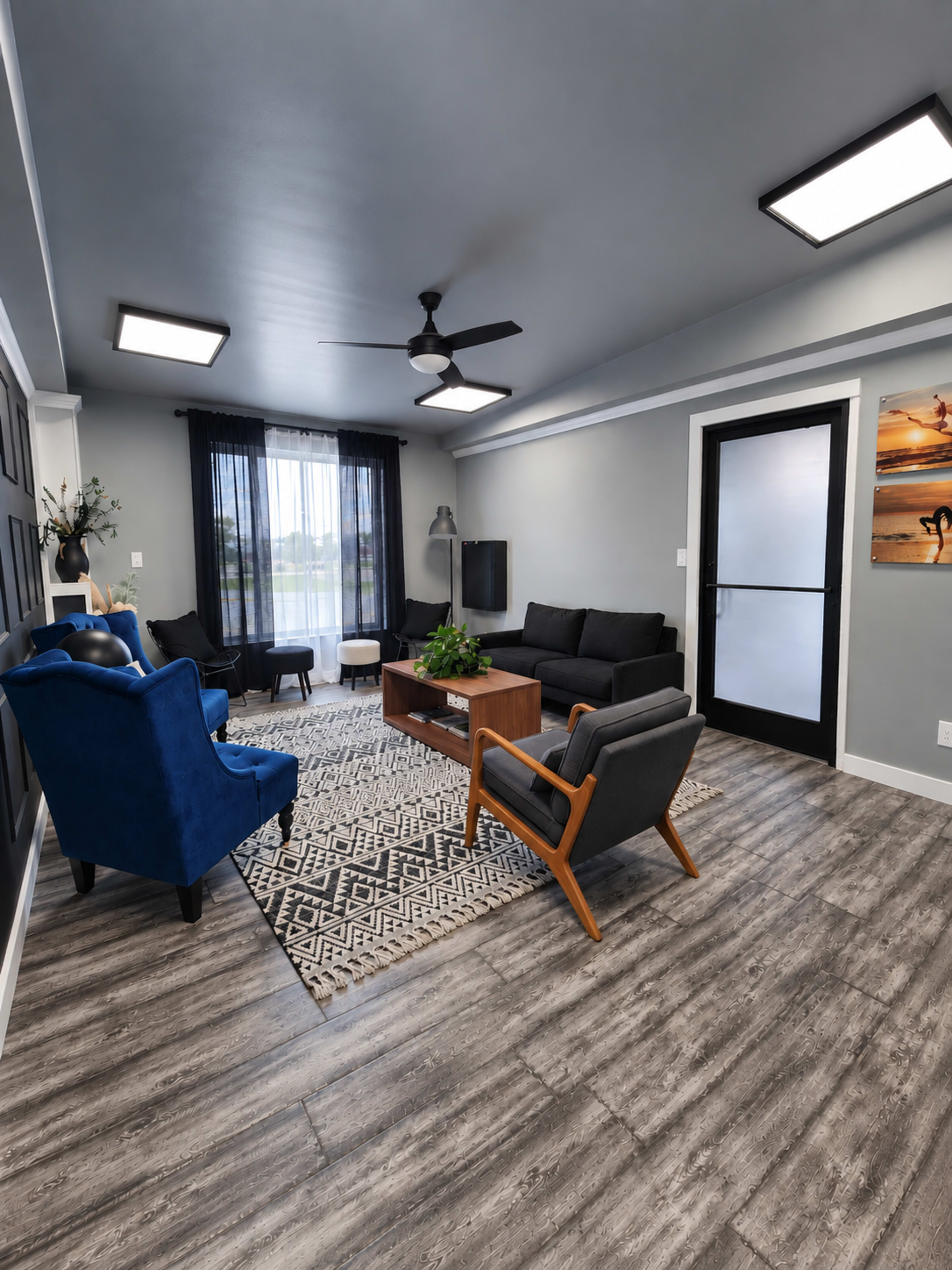 The image shows a modern living room with multiple seating options, a wooden coffee table, and large windows allowing natural light.