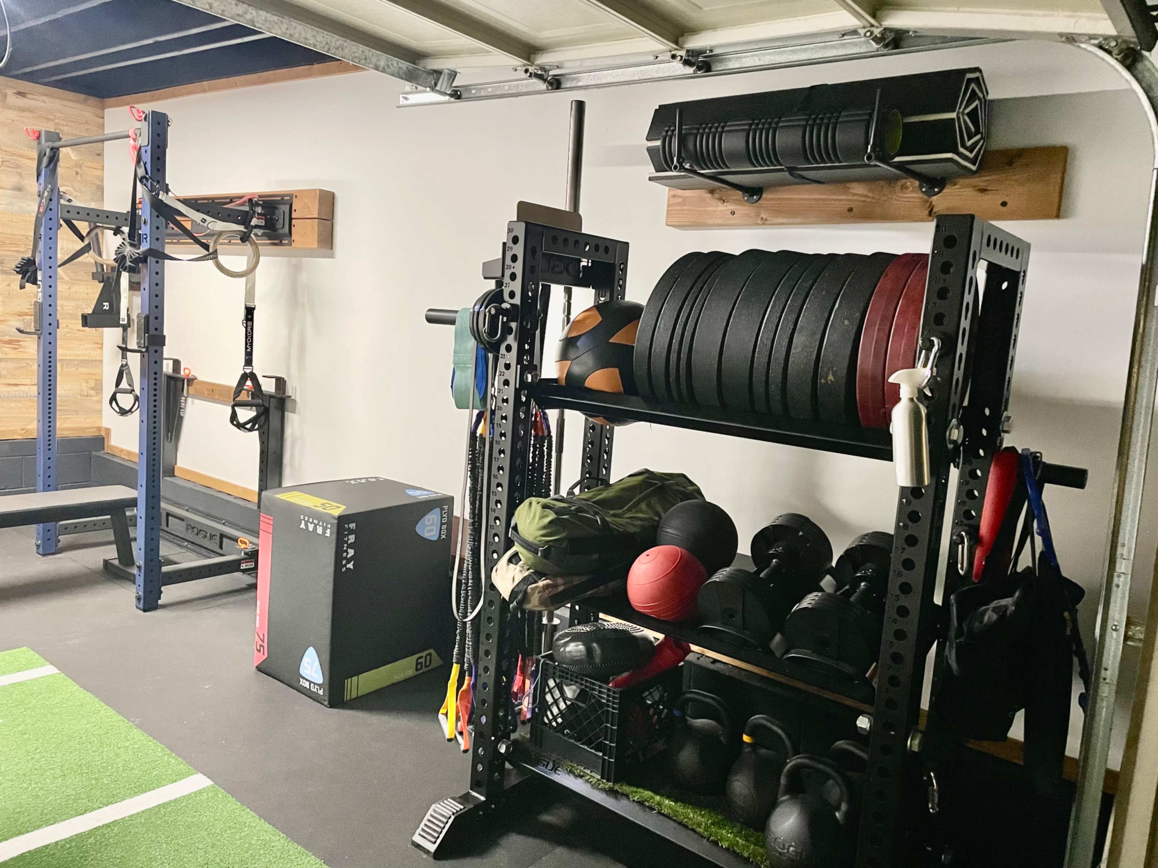 A well-organized home gym with weights, kettlebells, and exercise equipment neatly stored on shelves and racks.