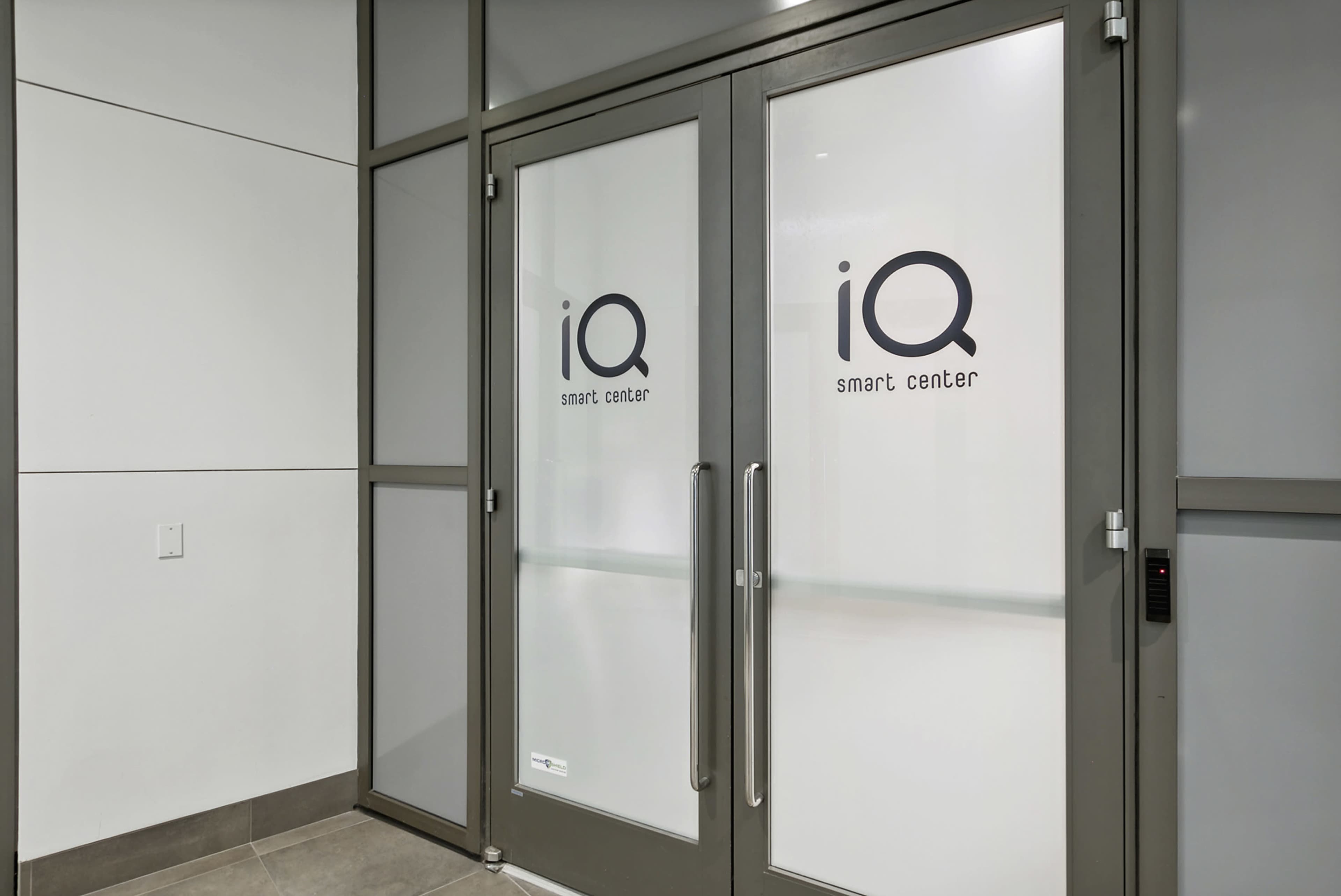 A set of frosted glass double doors labeled "iQ smart center" in a modern interior setting.