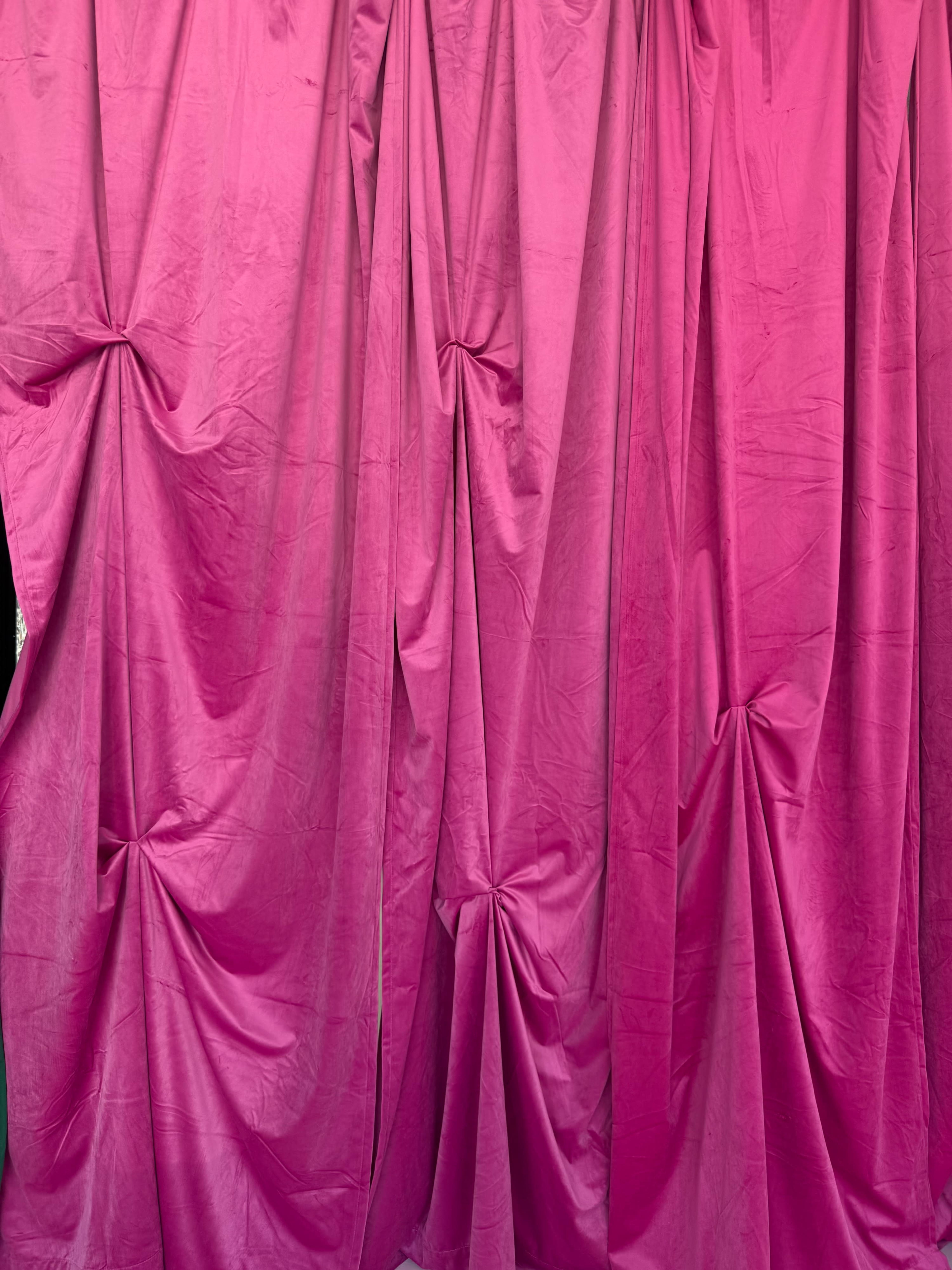 The image shows a set of pink fabric drapes arranged in a flowing pattern with folds and knots.