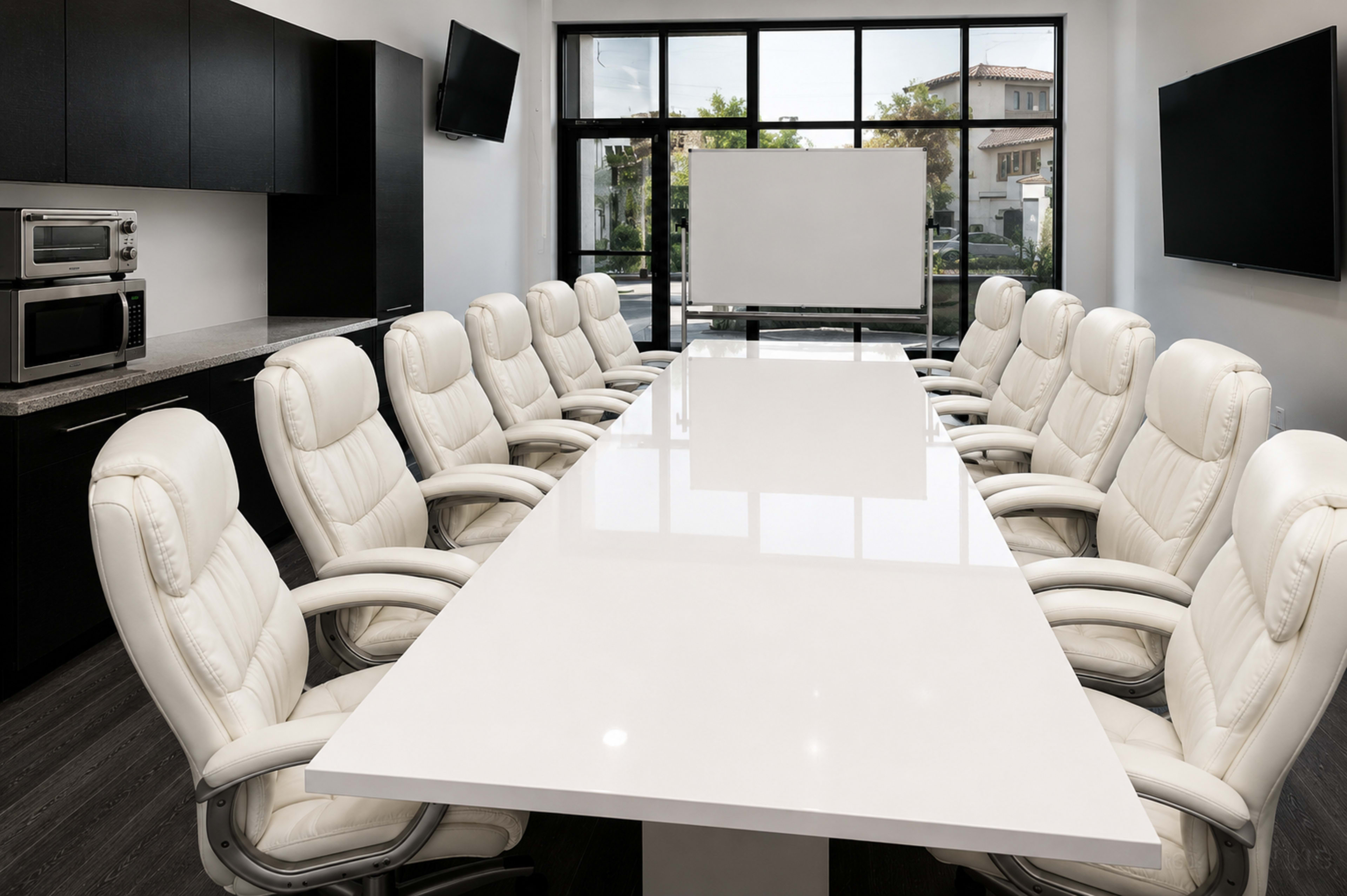 A modern conference room features a long, white table surrounded by twelve white ergonomic chairs, with large windows allowing natural light.