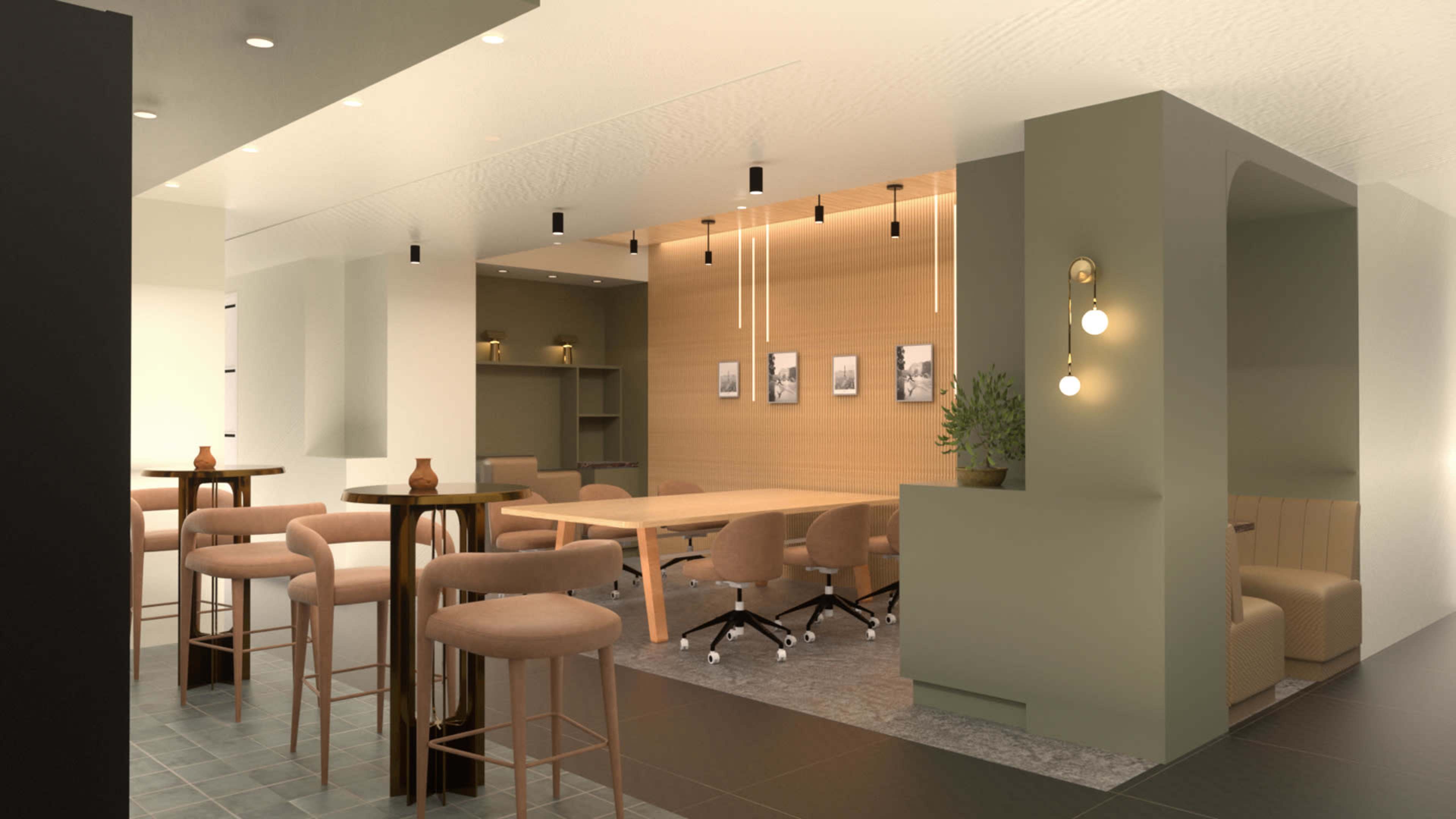 The image shows a modern, open-concept café with a seating area featuring tall stools, a long table, and a cozy nook with plants and wall art.