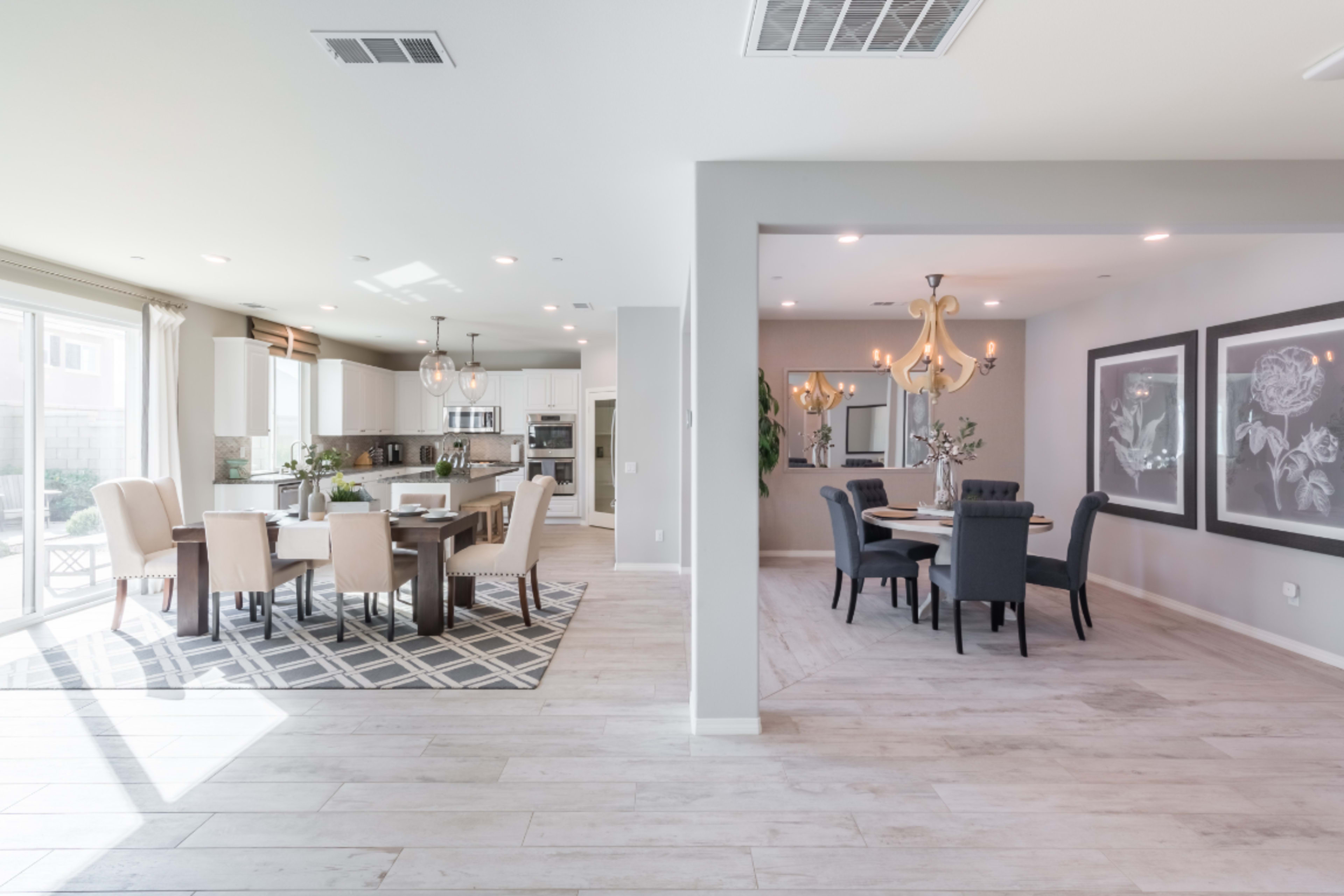 An open-concept living space featuring a dining area with a table and chairs on one side and a kitchen with modern appliances on the other.