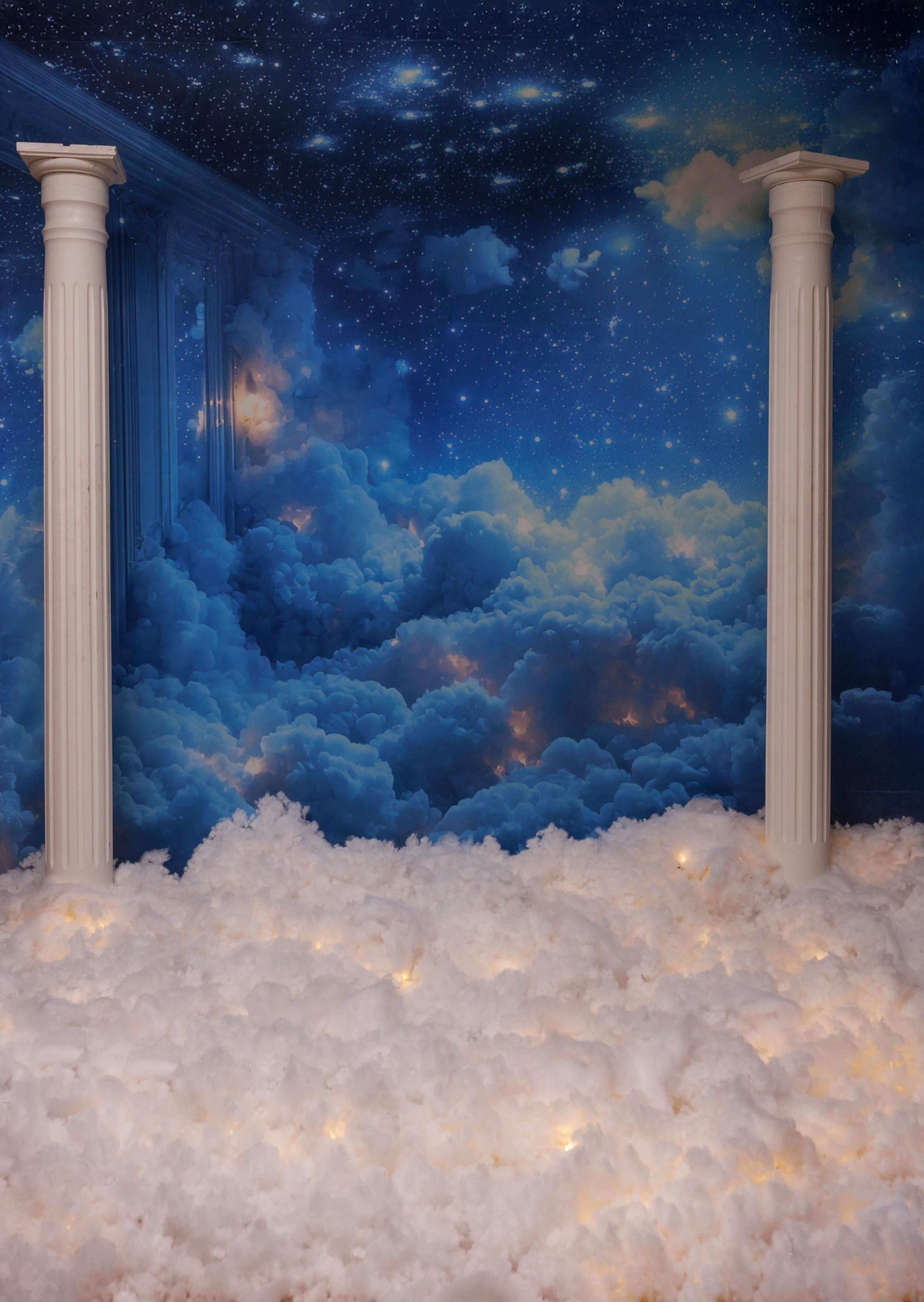 The image features a backdrop of a starry night sky with fluffy cloud formations and two white columns in the foreground.