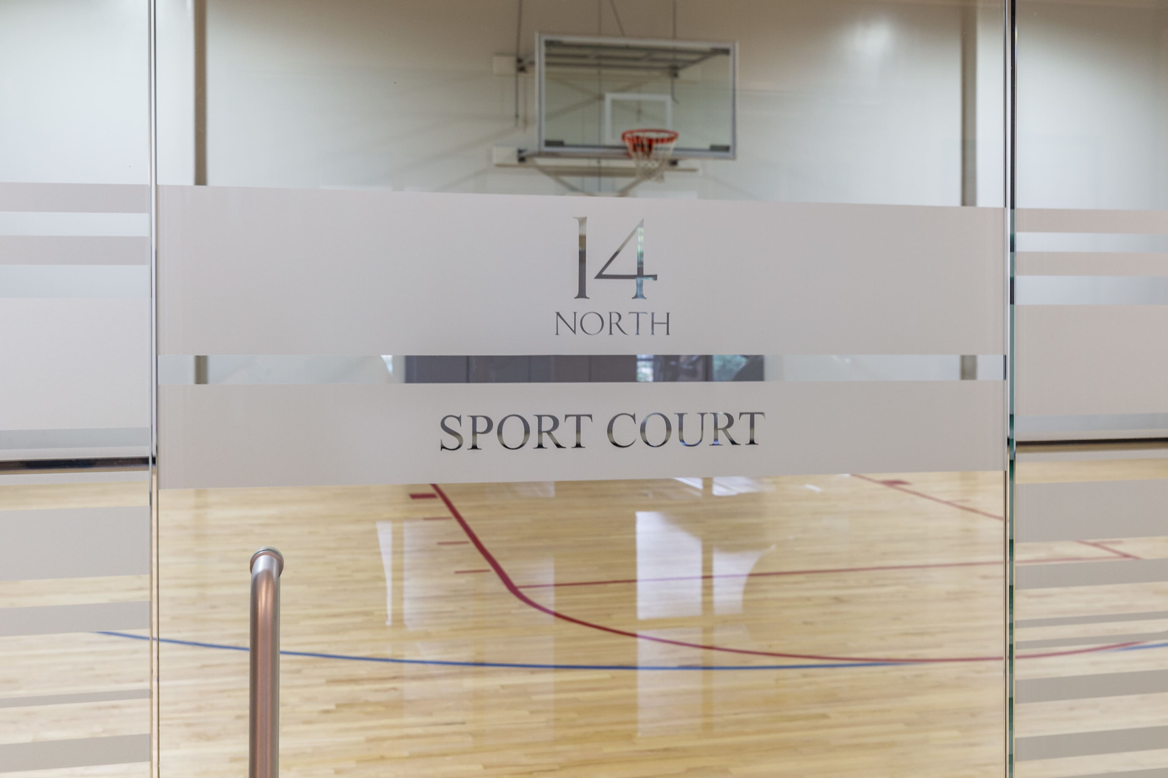 A glass door with the words "14 NORTH SPORT COURT" and a basketball hoop visible in the background.