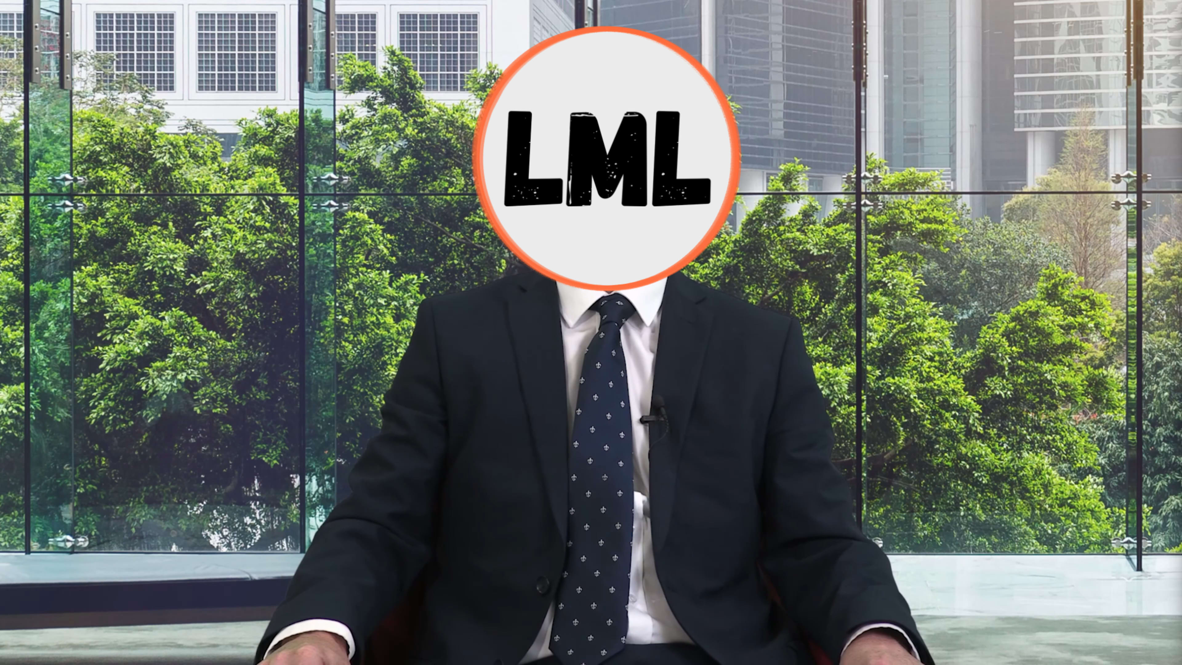 A person in a suit is seated in an office with large windows overlooking greenery, while their face is obscured by a circular logo that reads "LML."