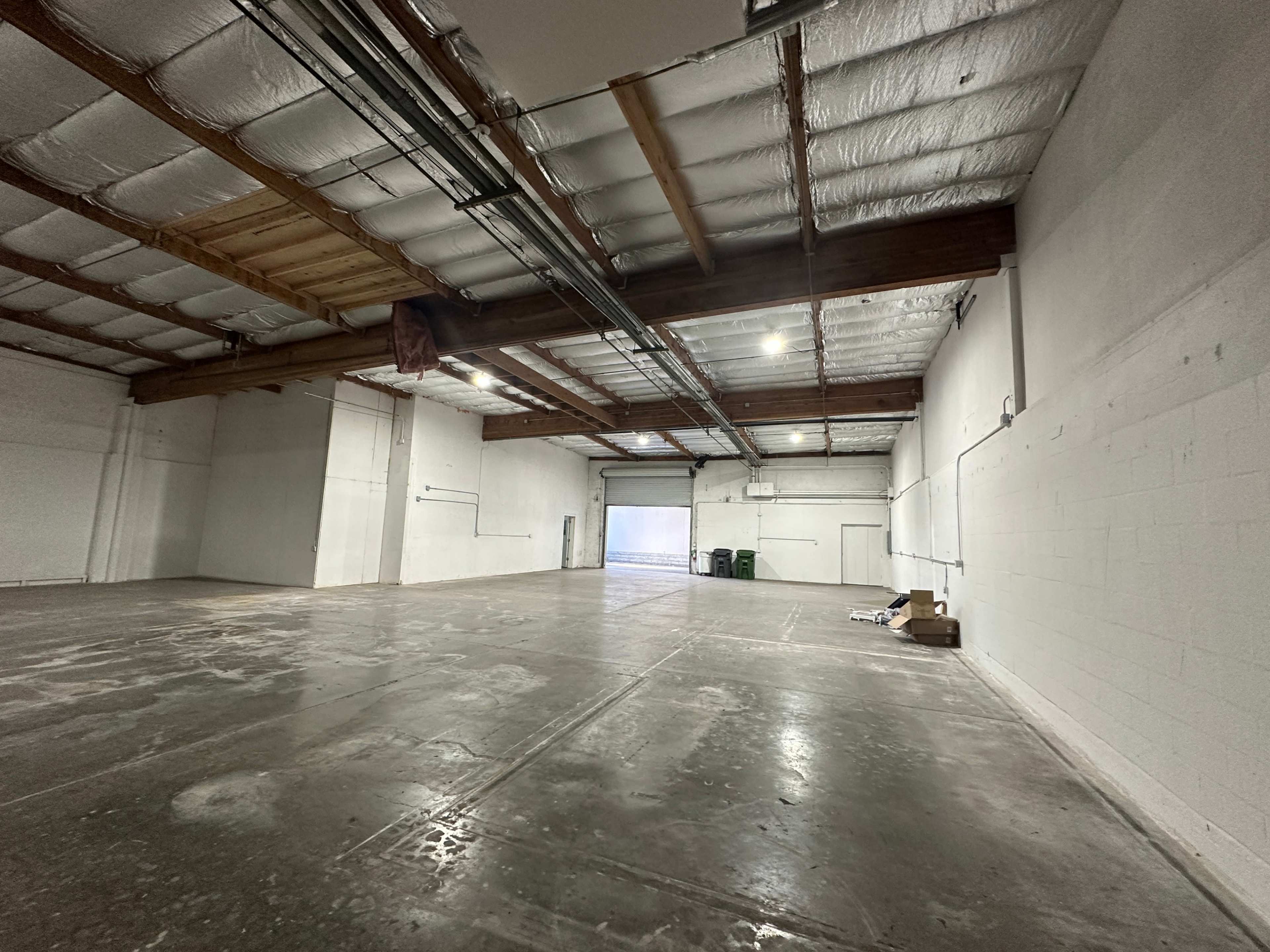 A large, empty warehouse space with concrete floors and exposed beams.