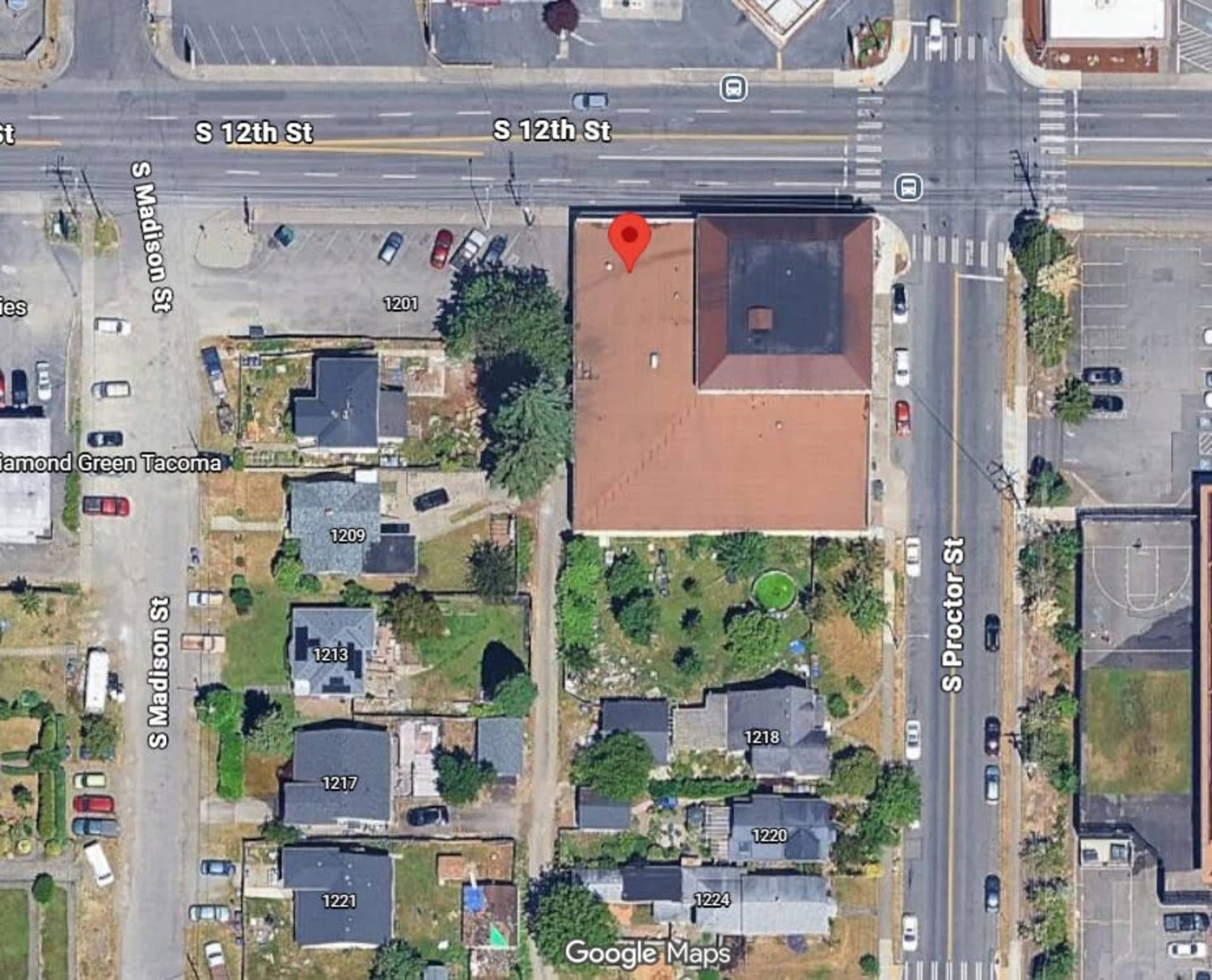 The image shows an overhead view of a neighborhood intersection with buildings, streets, and several residential properties.