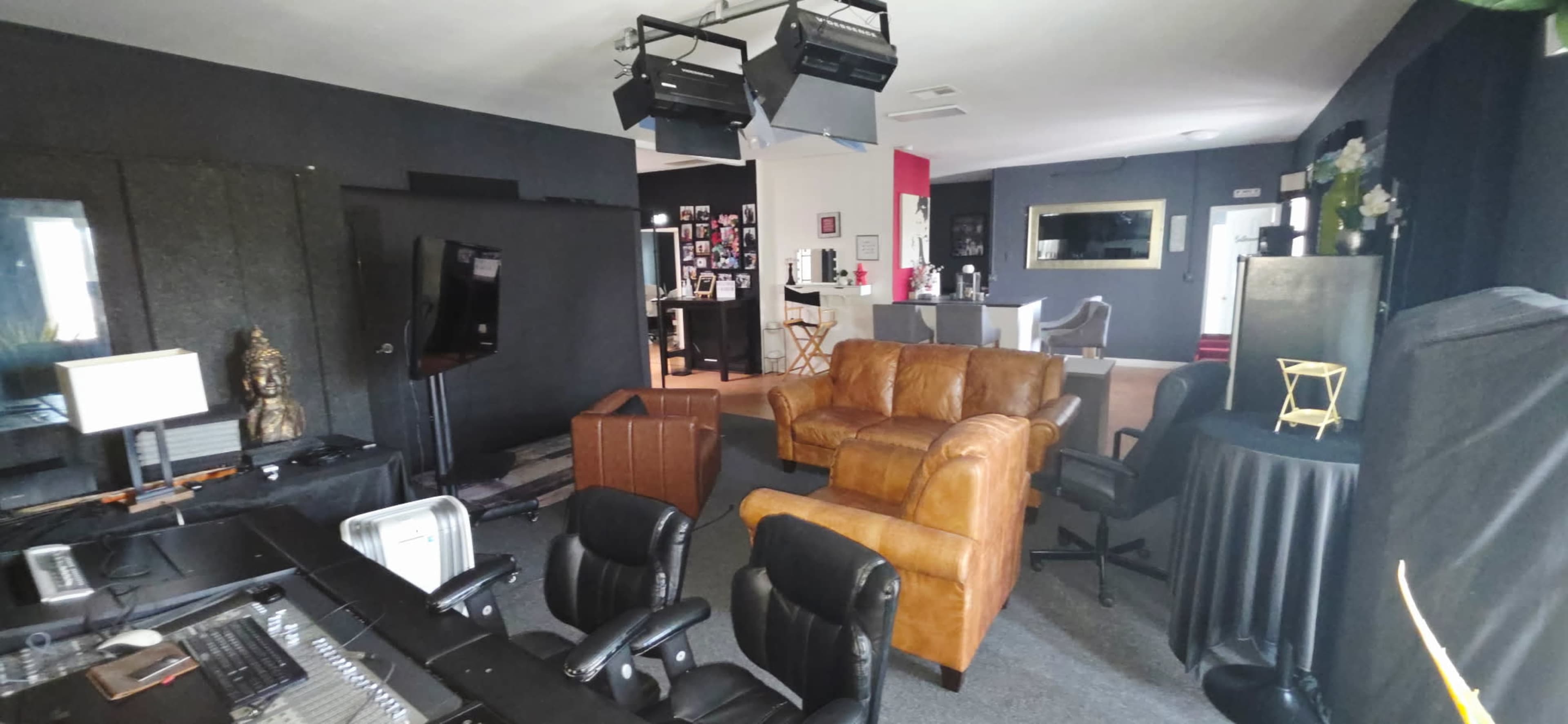 The image shows a room designed for multimedia use, featuring a leather couch, chairs, and various equipment, with areas defined for different activities.