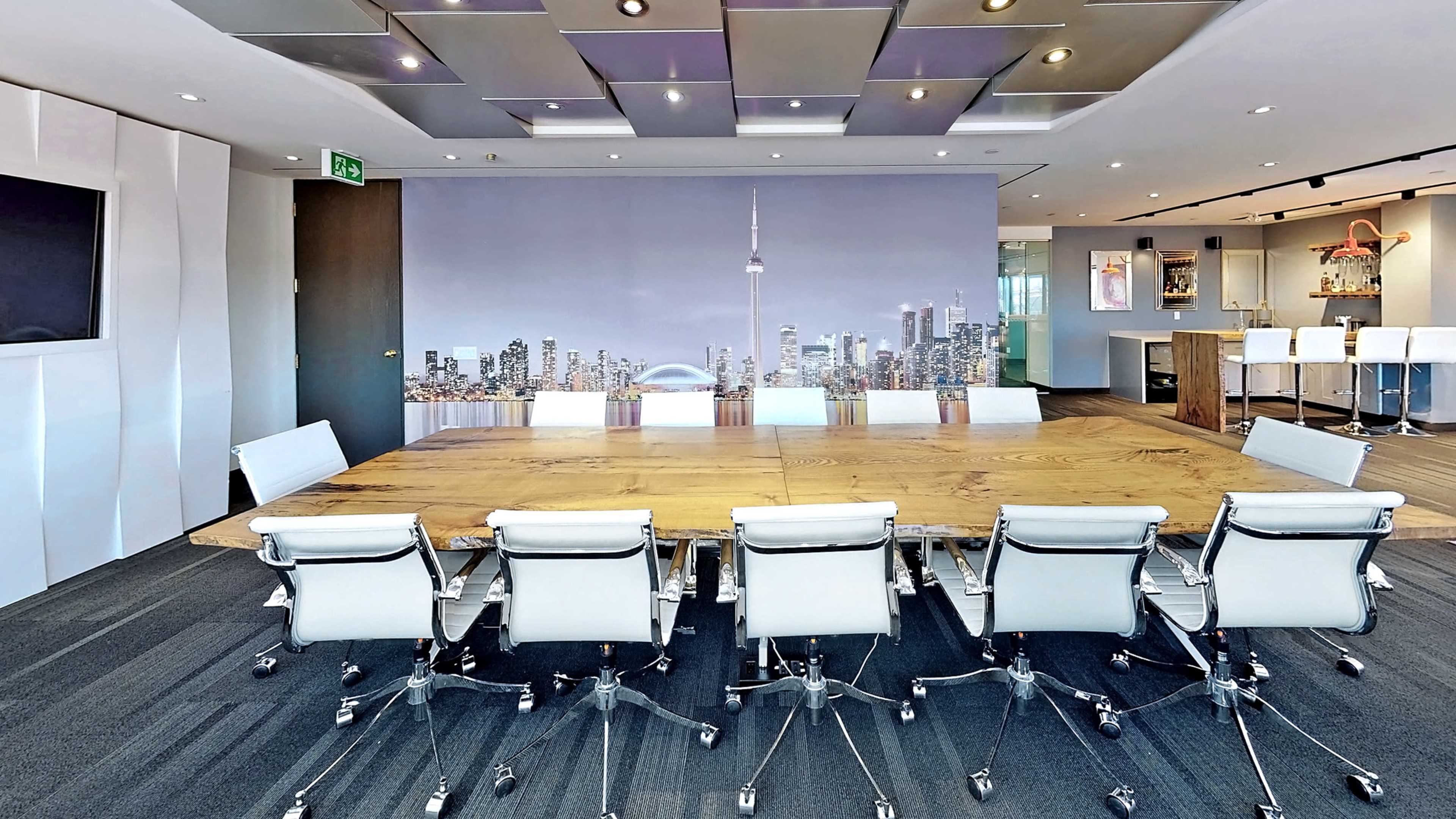 A modern conference room features a large wooden table surrounded by sleek white chairs, with a city skyline mural in the background.