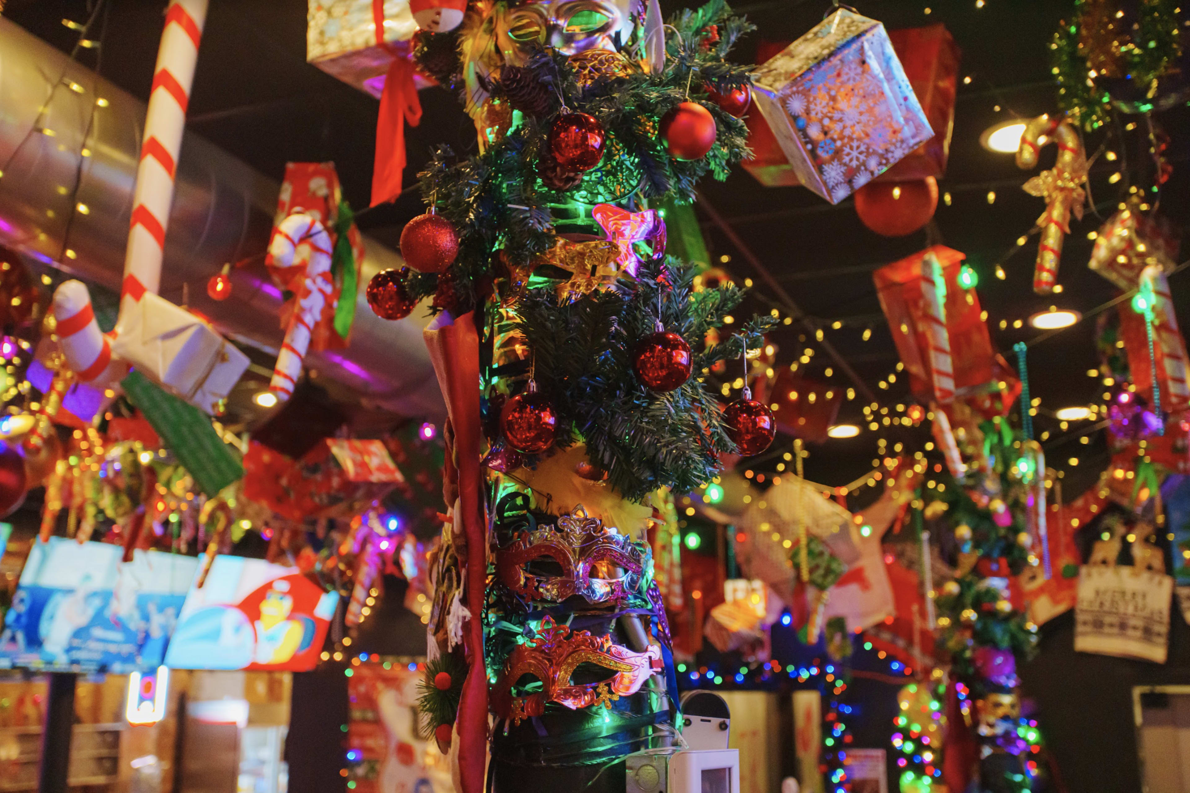 A decorated interior filled with colorful ornaments, garlands, and holiday gifts hanging from the ceiling.