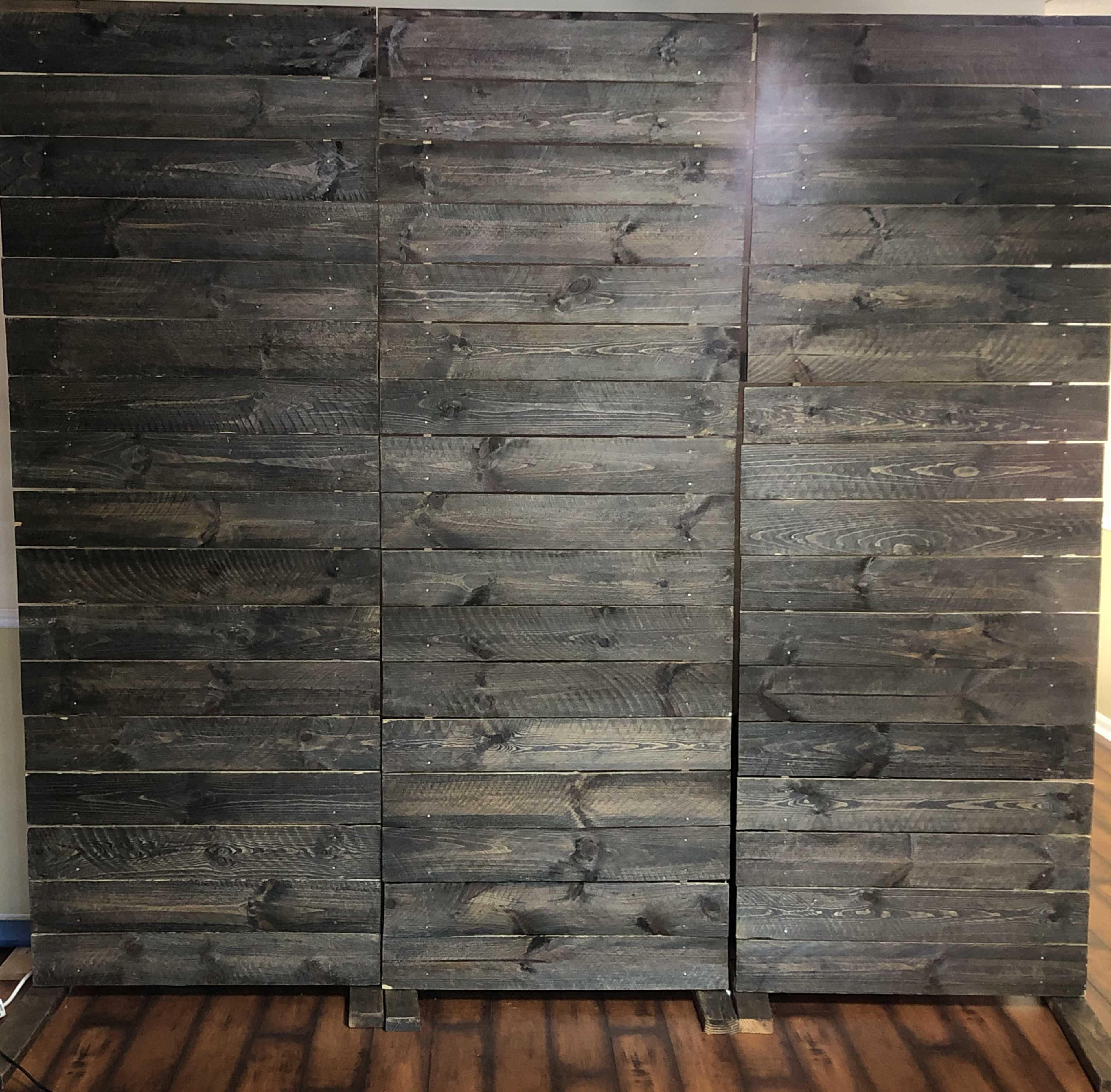 A large wooden panel screen made of dark, horizontally aligned planks.