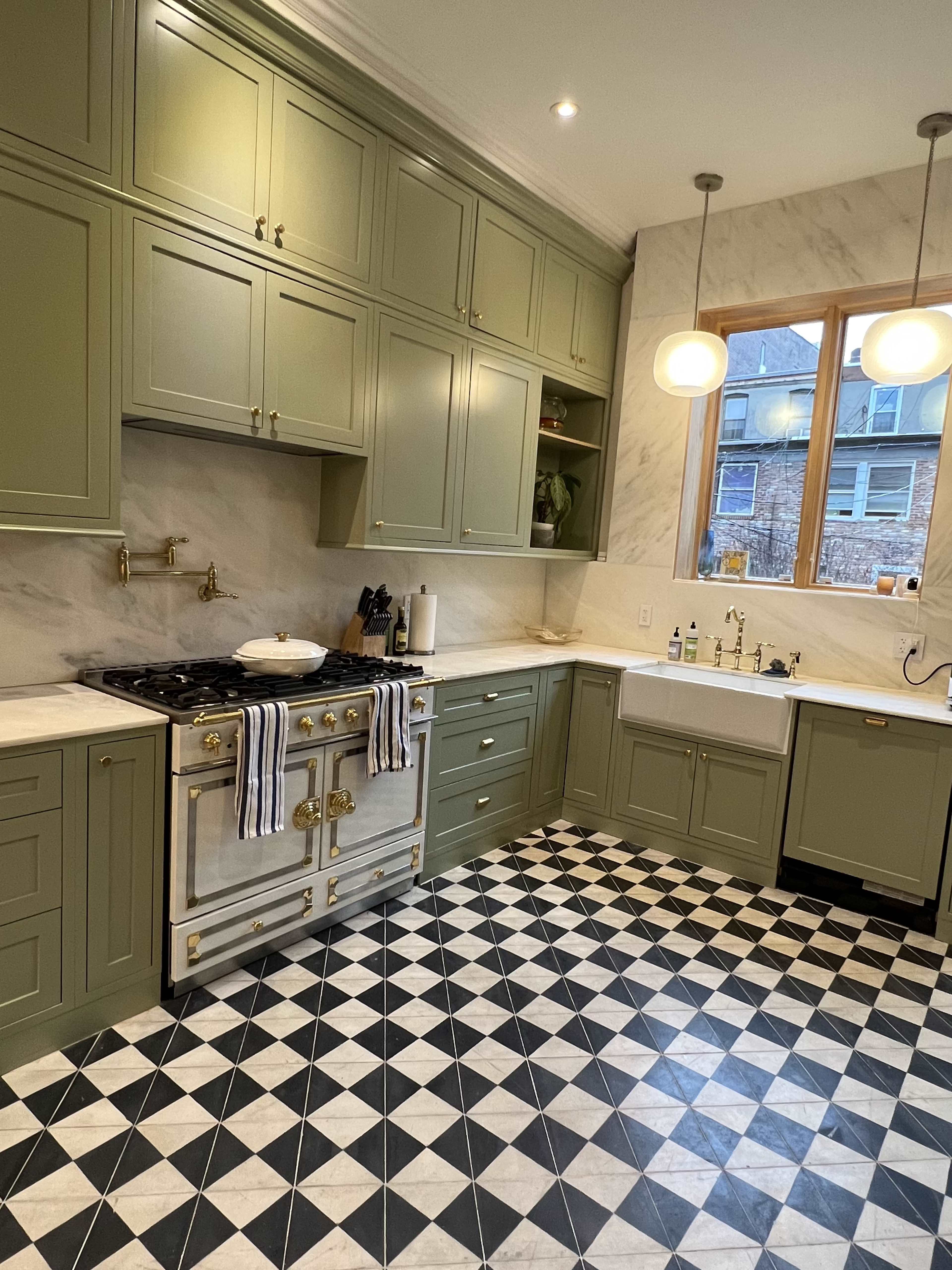 The image shows a kitchen with green cabinets, a classic stove, and a black-and-white checkered floor.