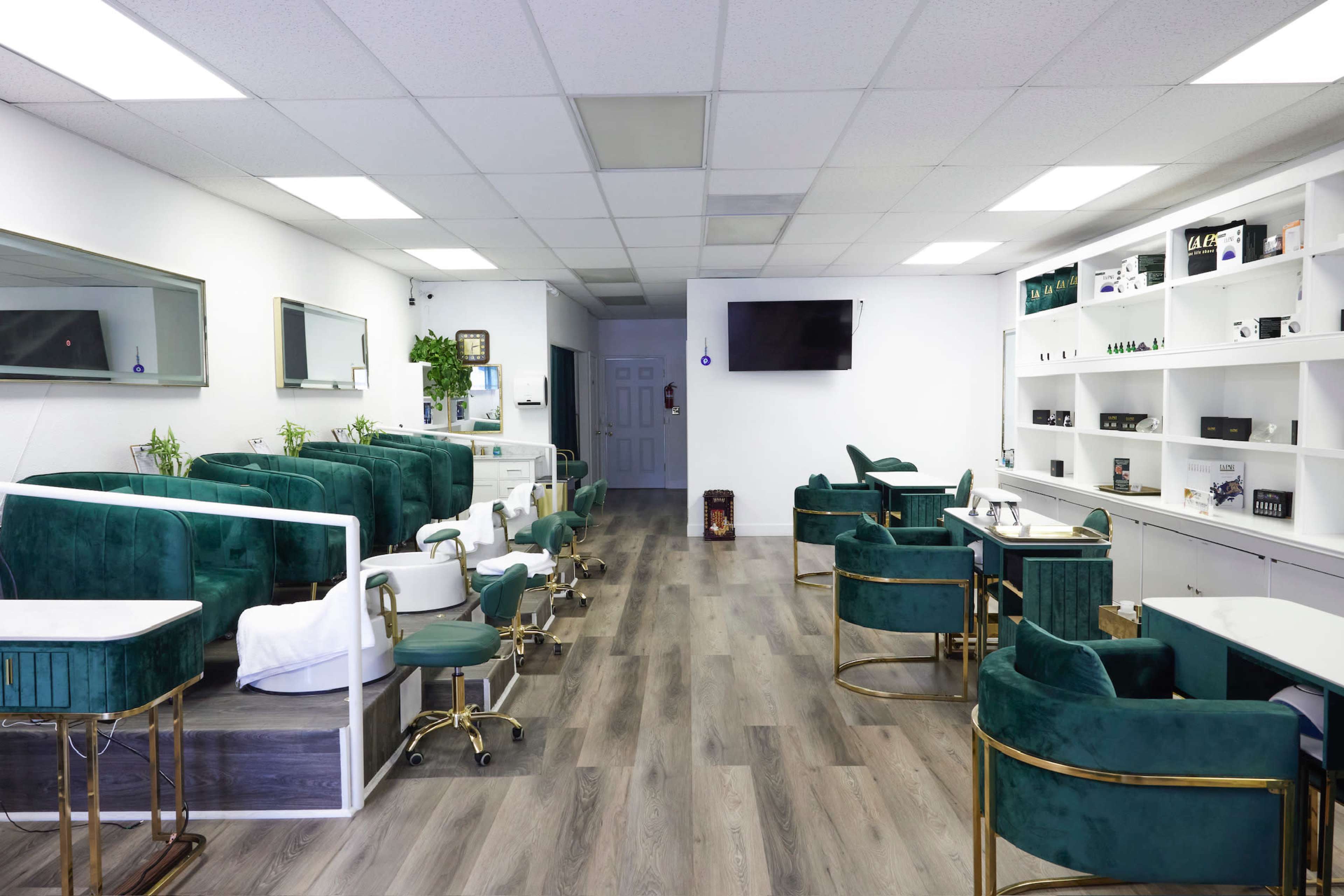 The image shows a modern nail salon with green chairs, a series of white treatment stations, and a bright, open layout.