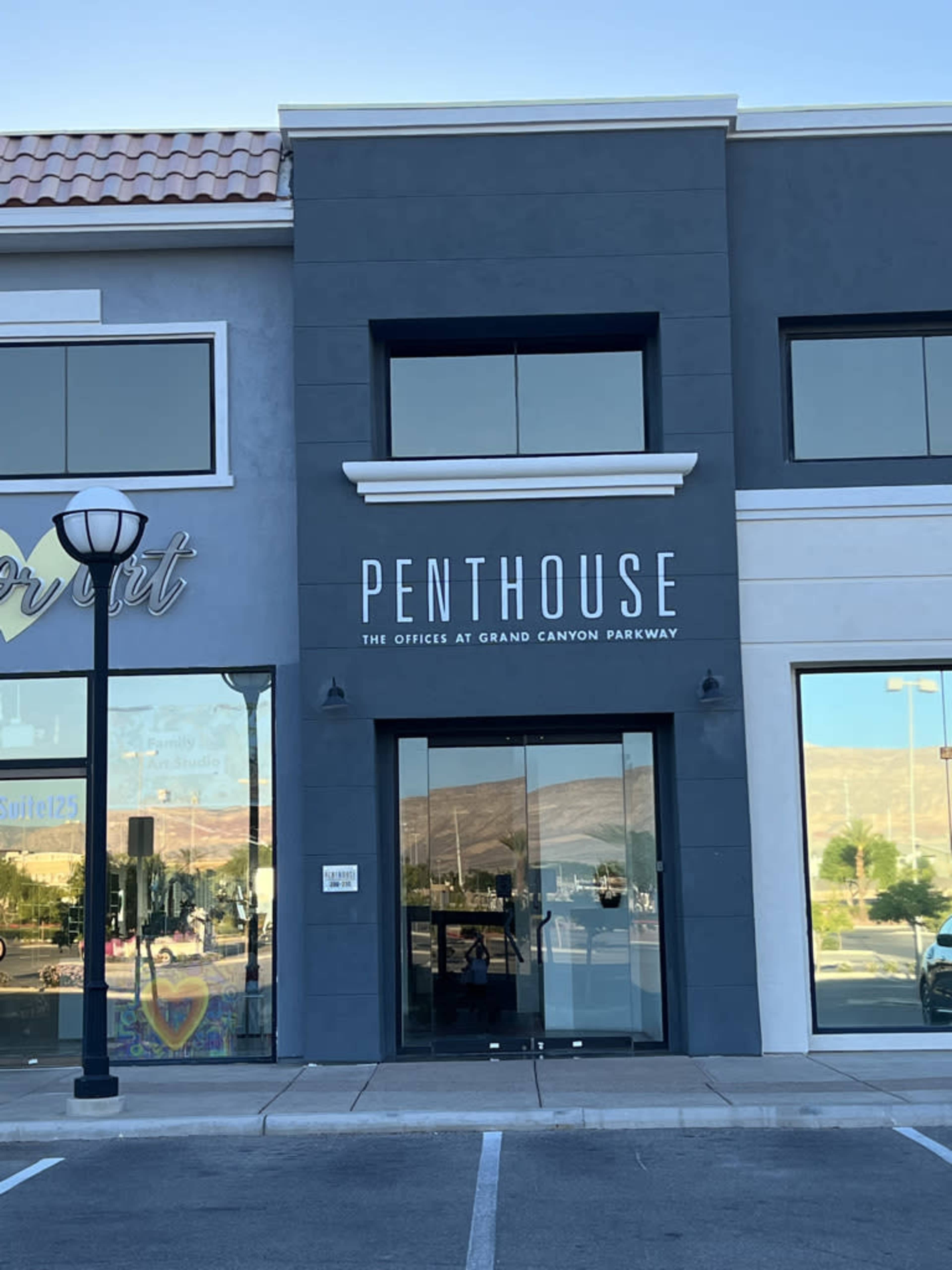 A building facade featuring a sign that reads "PENTHOUSE" and "THE OFFICES AT GRAND CANYON PARKWAY."