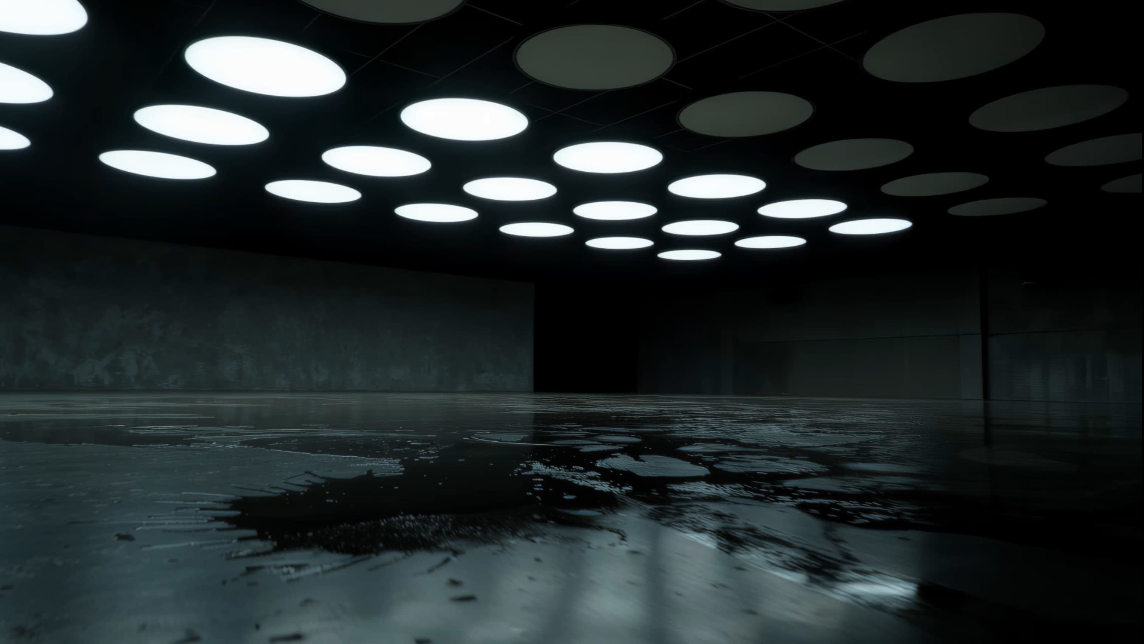 A dimly lit room features a shiny, wet floor and circular ceiling lights casting an even glow.