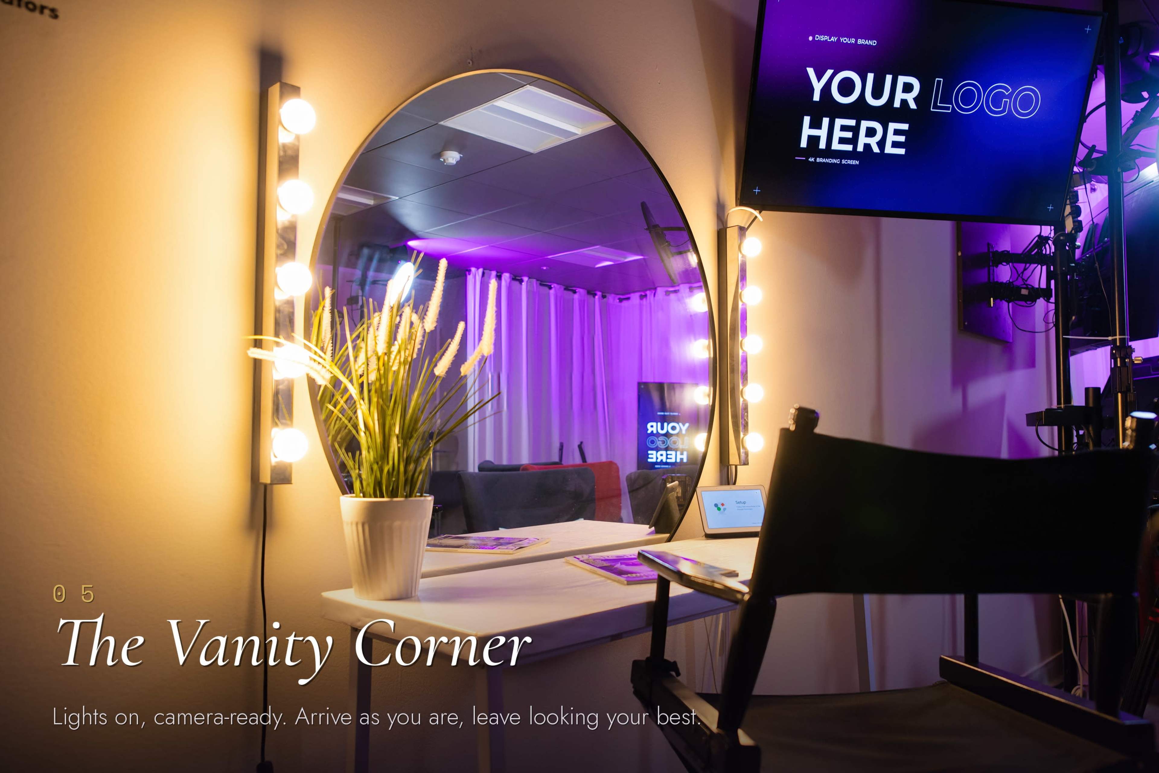 The image shows a circular vanity mirror with lights, a small potted plant, and a black director's chair in a stylish studio setting.