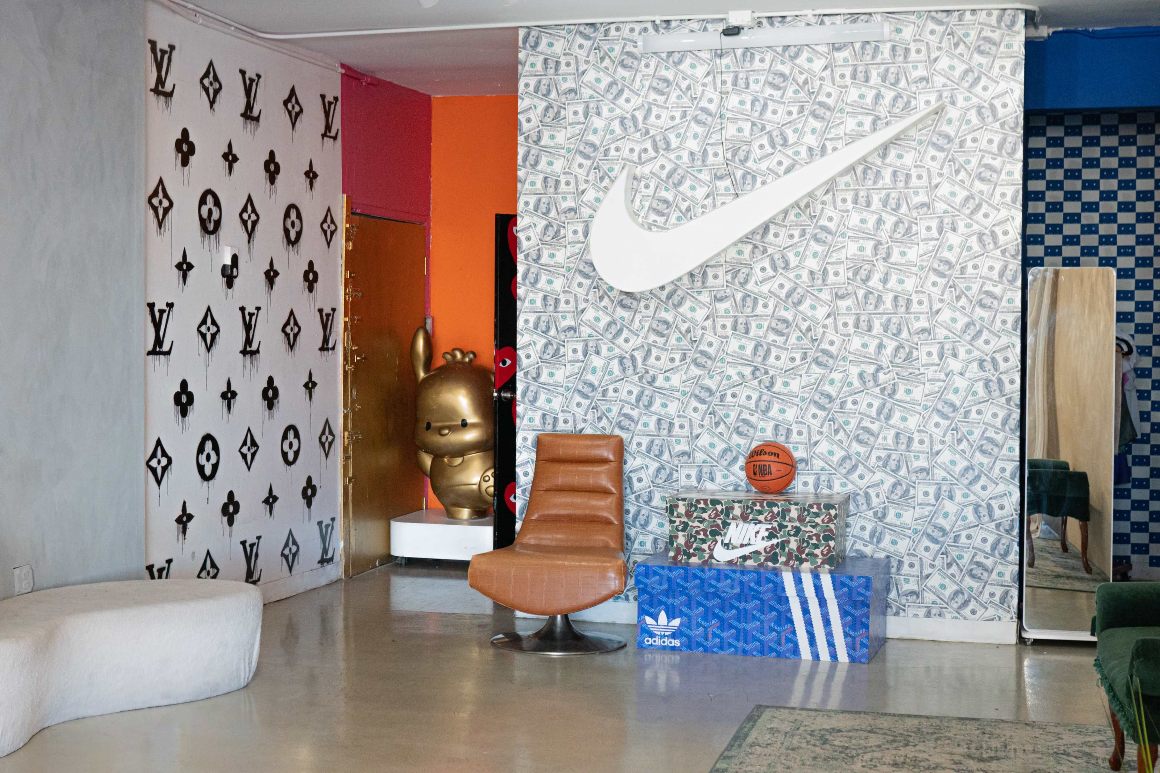 The image shows a stylish room featuring a Nike-themed wall, a basketball on a decorative box, a modern chair, and various designer logos on the walls.
