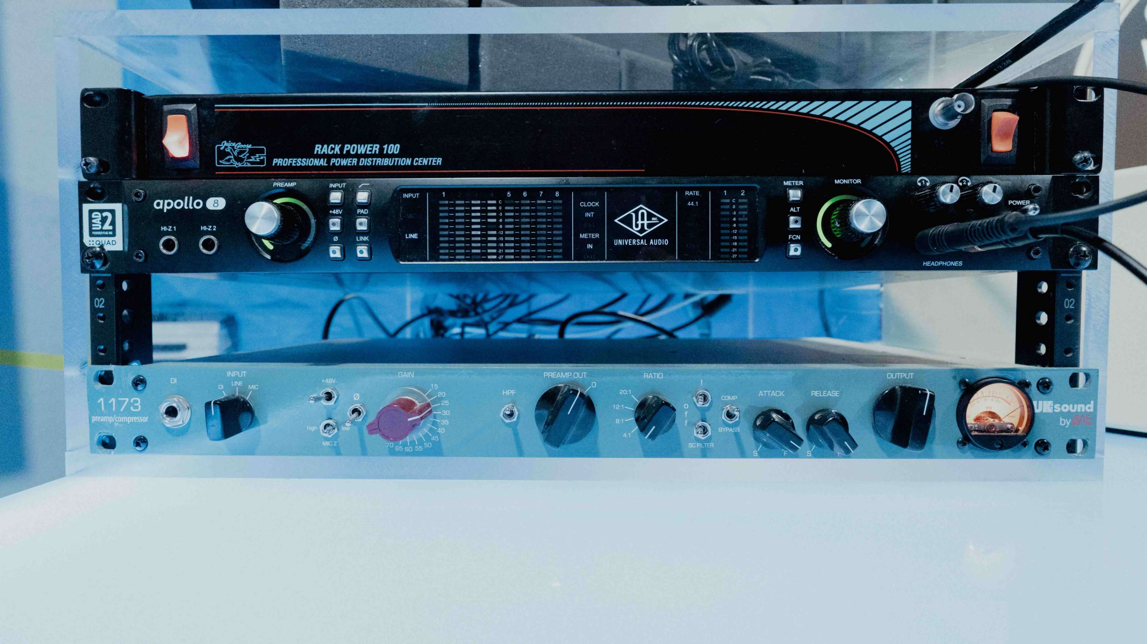 The image shows a rack-mounted audio equipment setup featuring a power distribution unit and a channel strip processor.