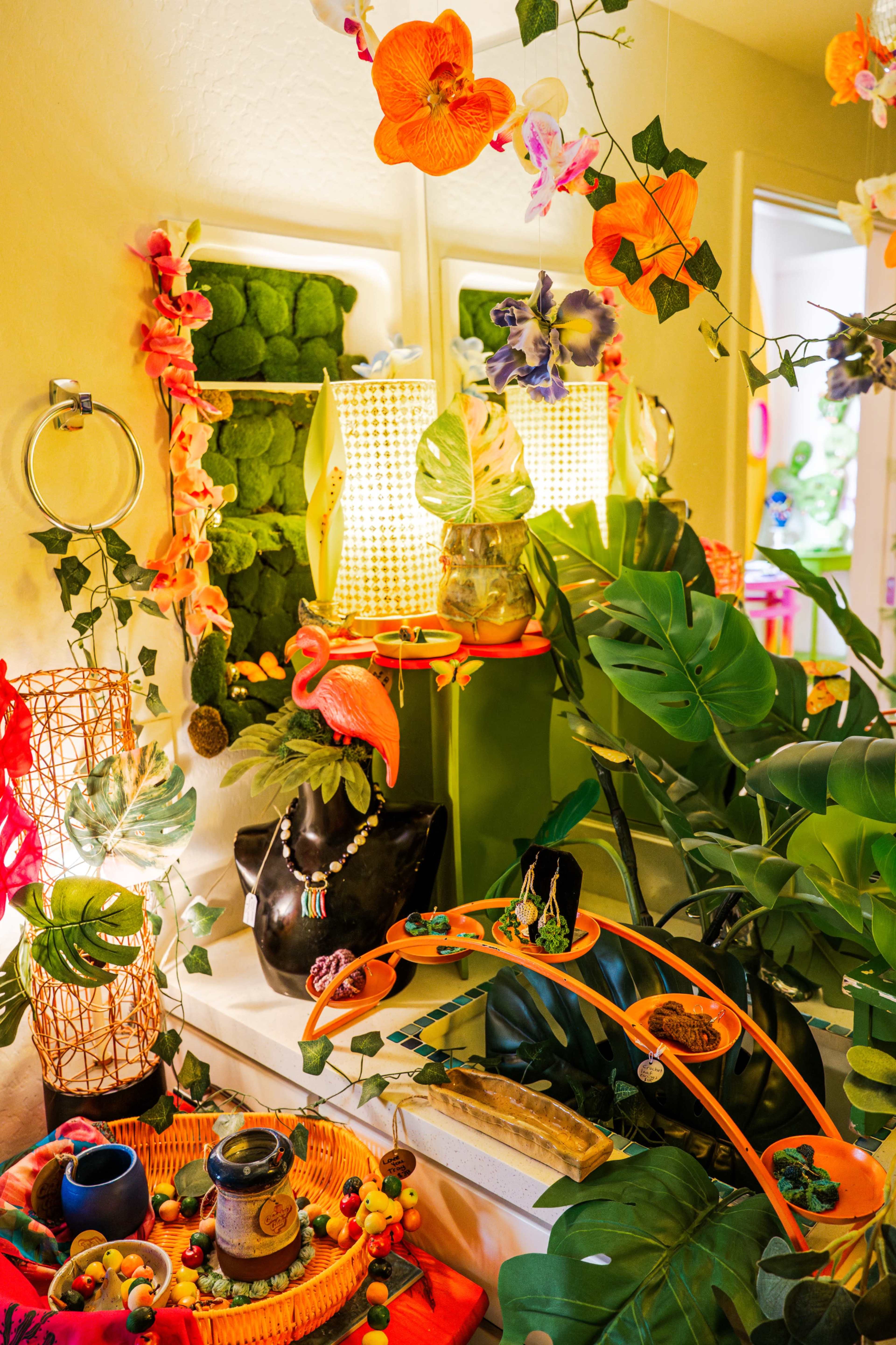 The image shows a vibrant and lush indoor space filled with various plants, colorful decorations, and unique home accessories.