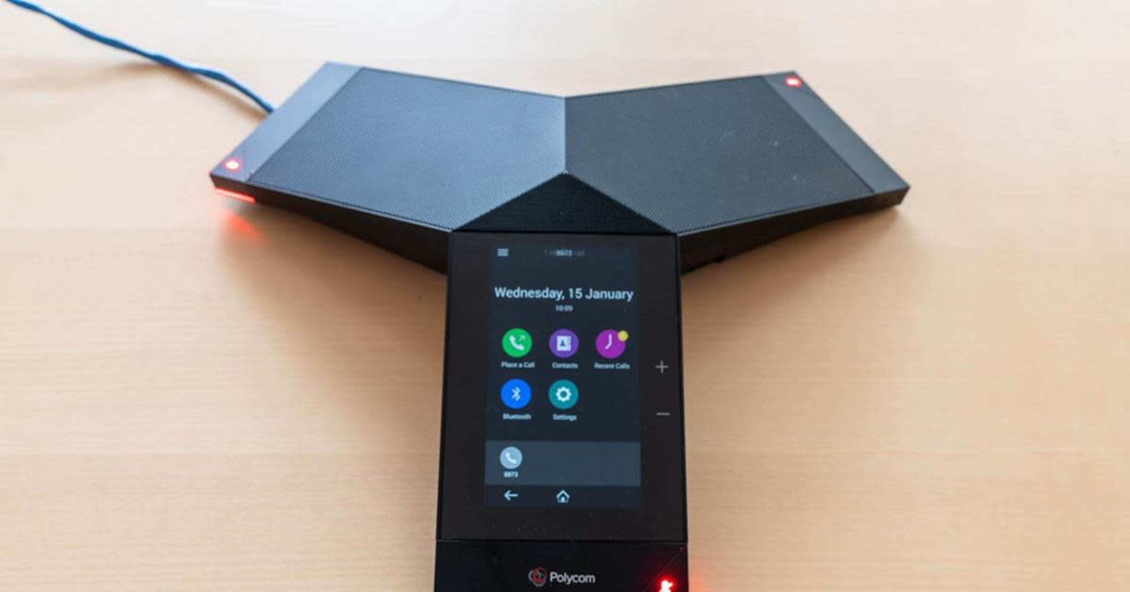 A Polycom conference phone with a digital display and two angled speaker components.