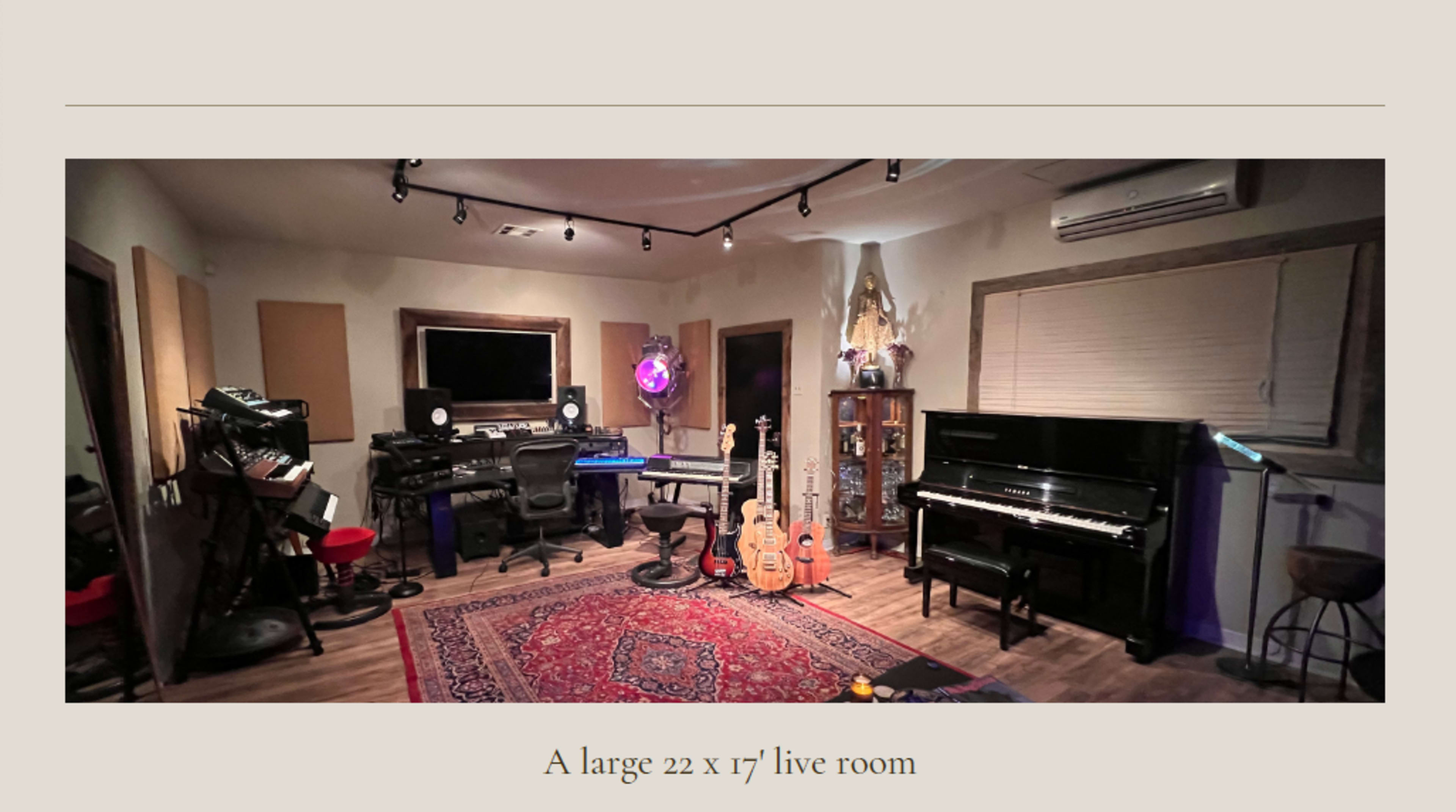 A spacious live room measuring 22 by 17 feet, equipped with musical instruments, recording equipment, and a grand piano.