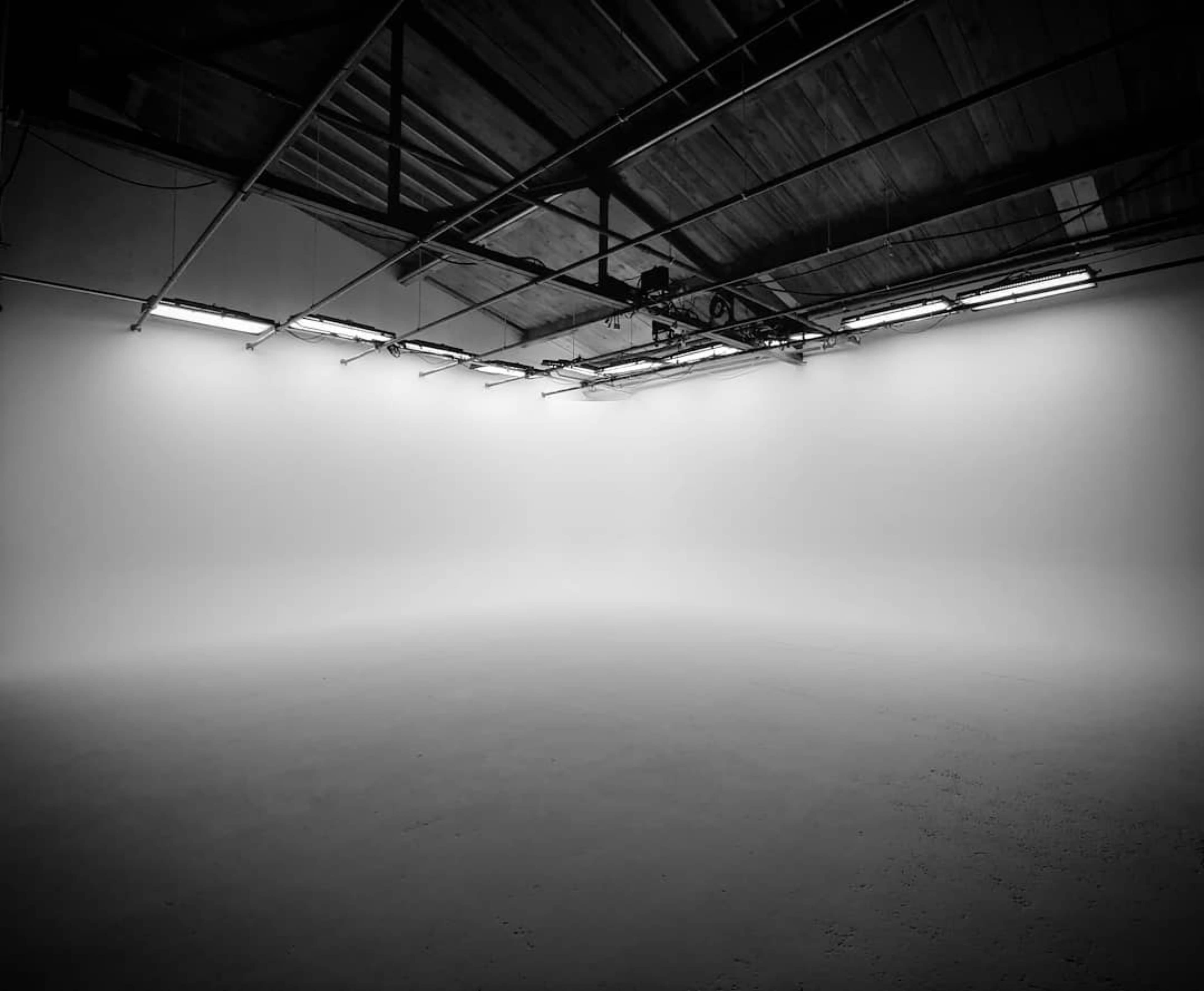 An empty, well-lit studio space with a smooth, blank wall.