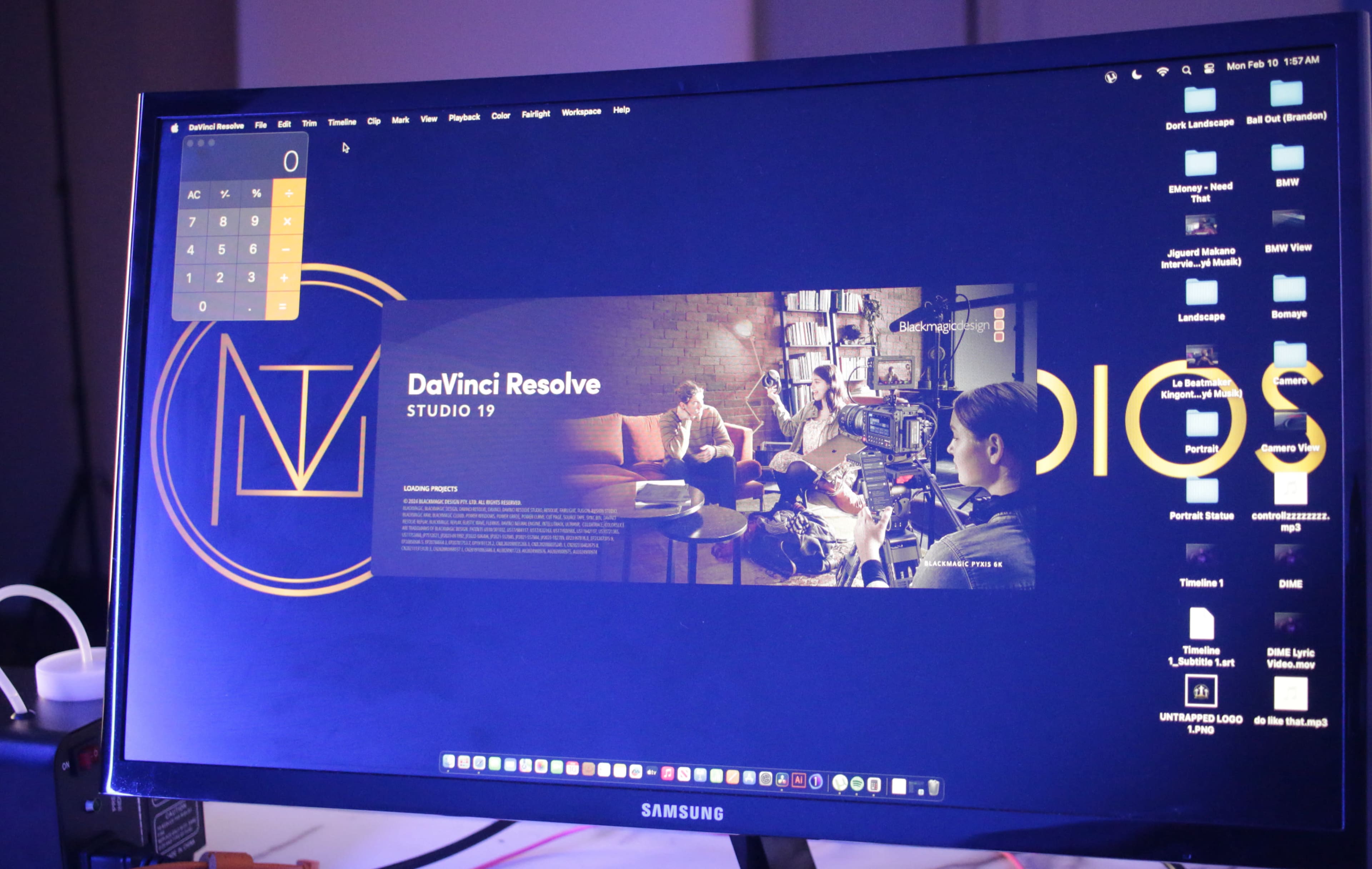 A computer monitor displays the DaVinci Resolve Studio 19 interface alongside a calculator app, with various icons visible on the desktop.