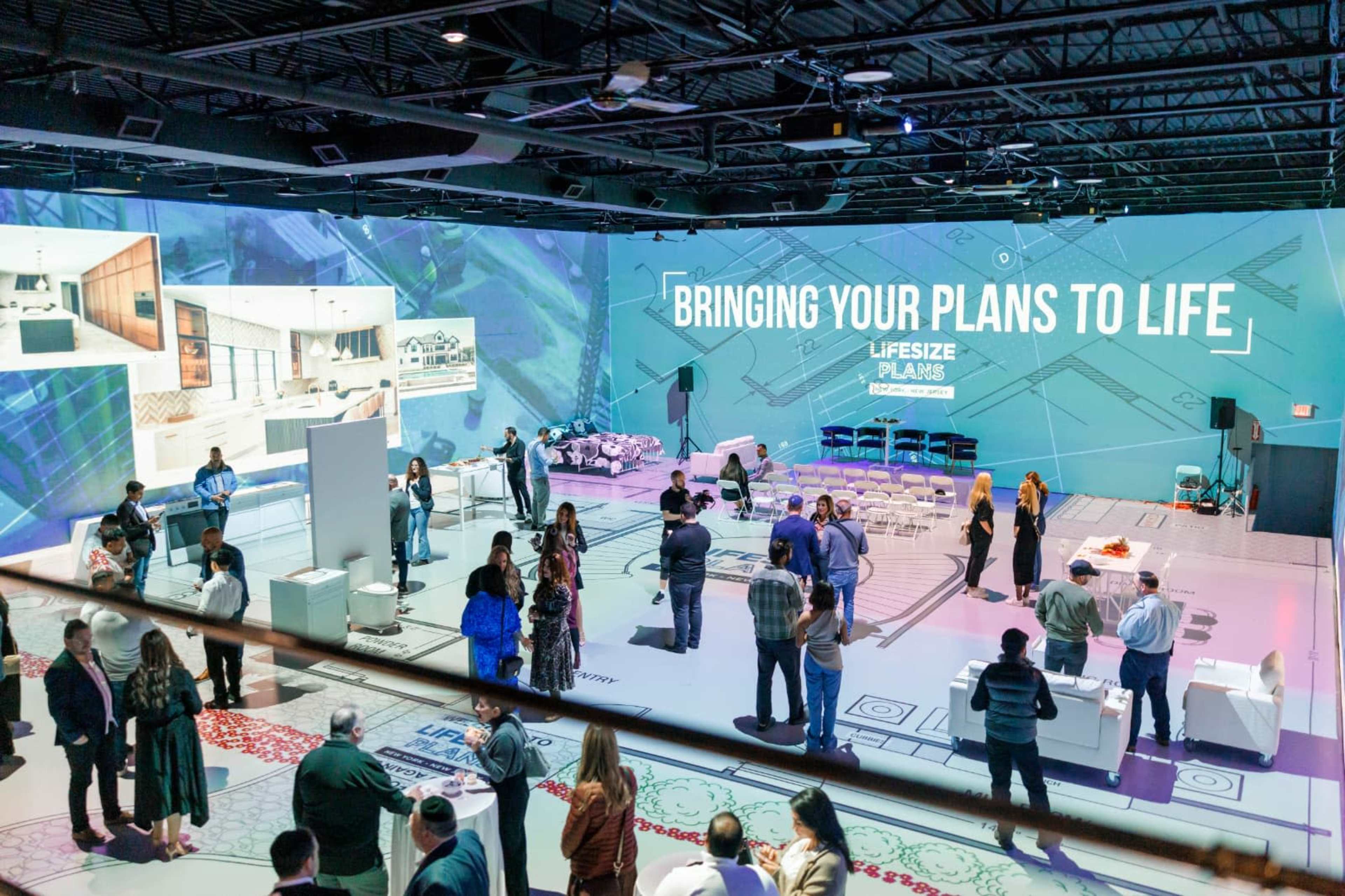 A large event space displays digital presentations on walls while attendees engage in discussions and networking.