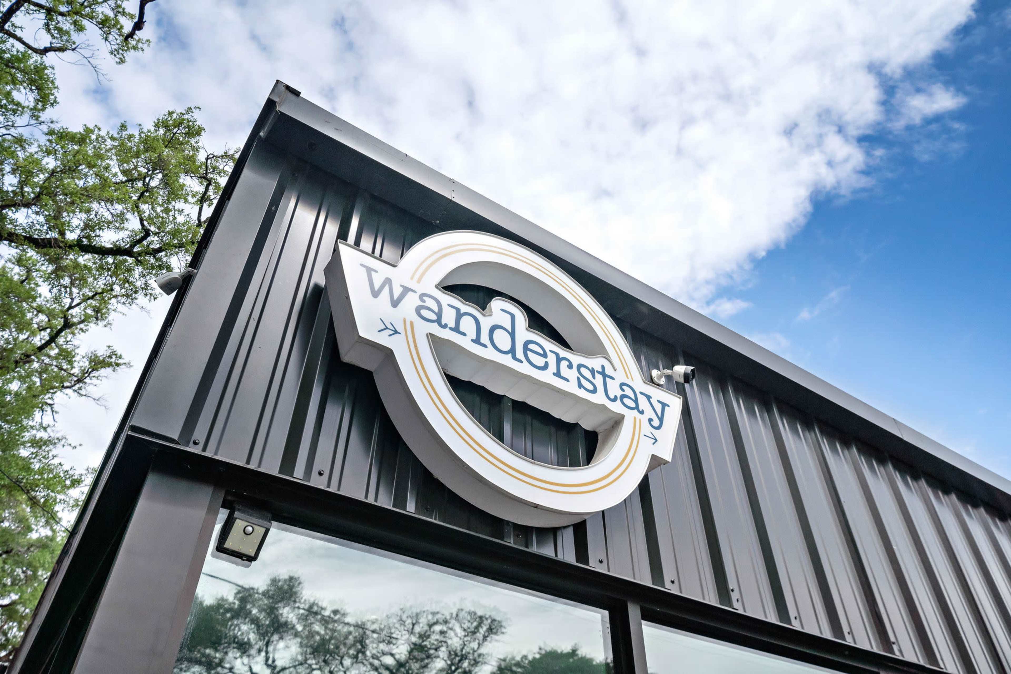 The image shows a building with a sign that reads "wanderstay" mounted on its exterior.