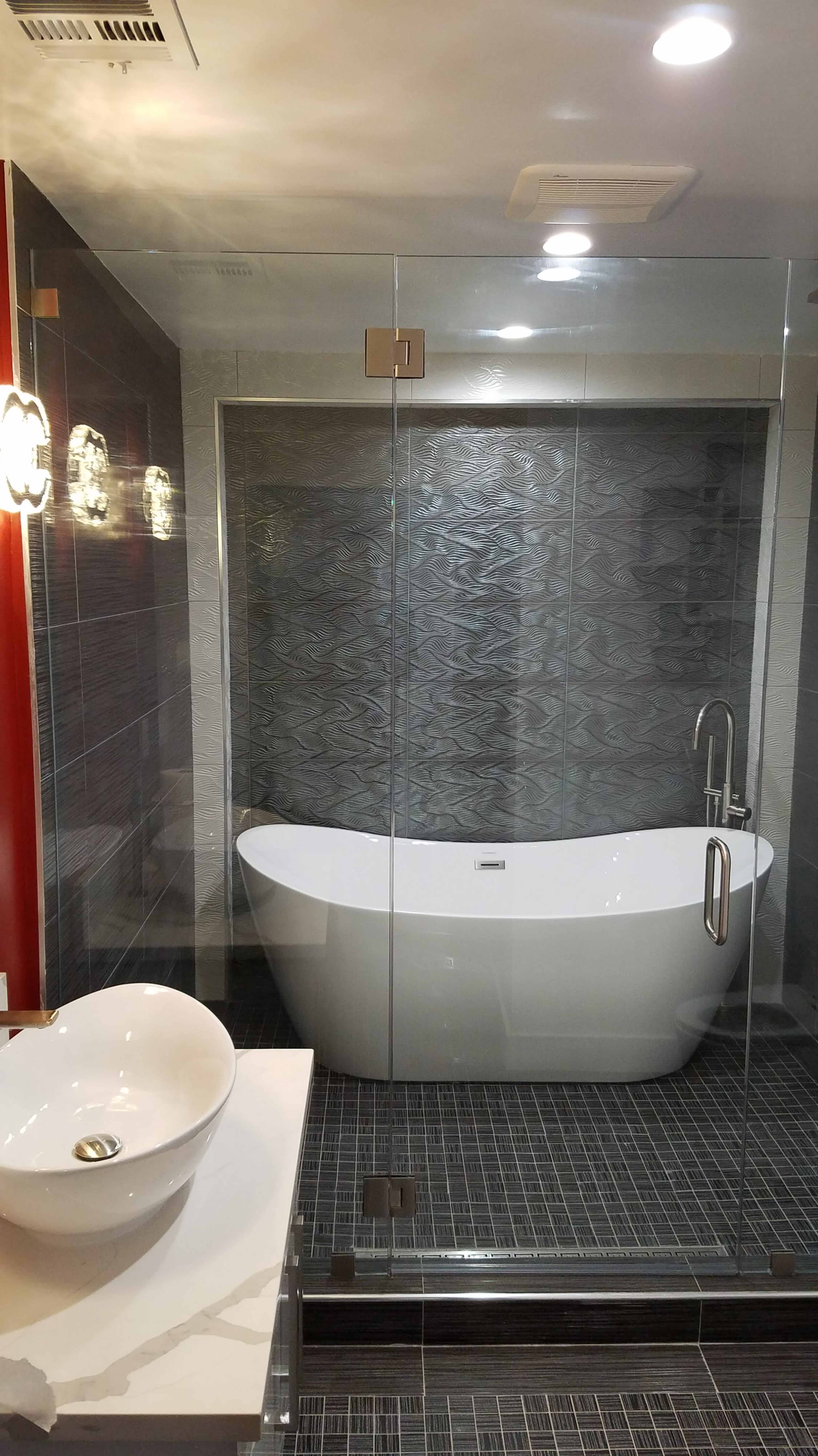 A modern bathroom featuring a freestanding white tub, a glass shower enclosure, and a vessel sink on a countertop.