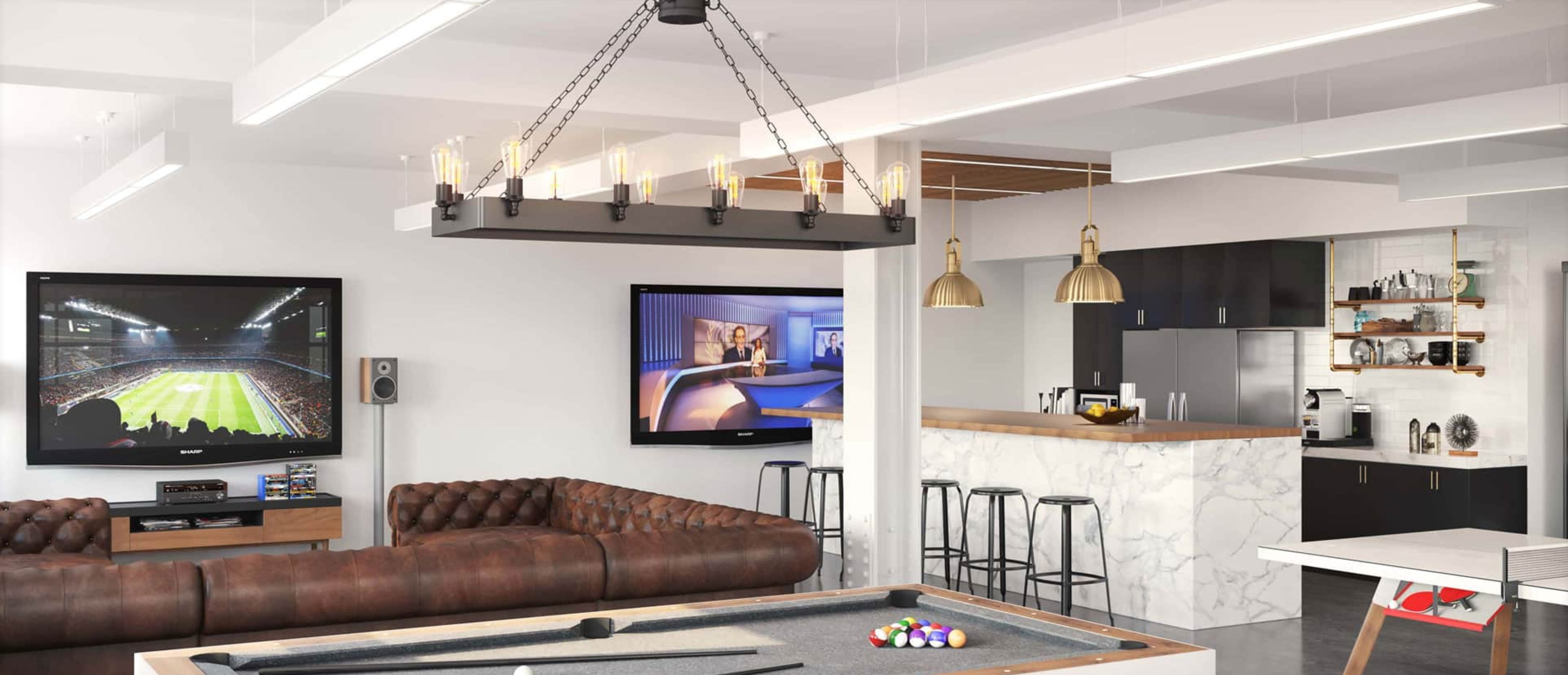 The image shows a modern game room featuring a pool table, a large TV displaying a sports match, and a sleek kitchen area with bar stools and pendant lighting.