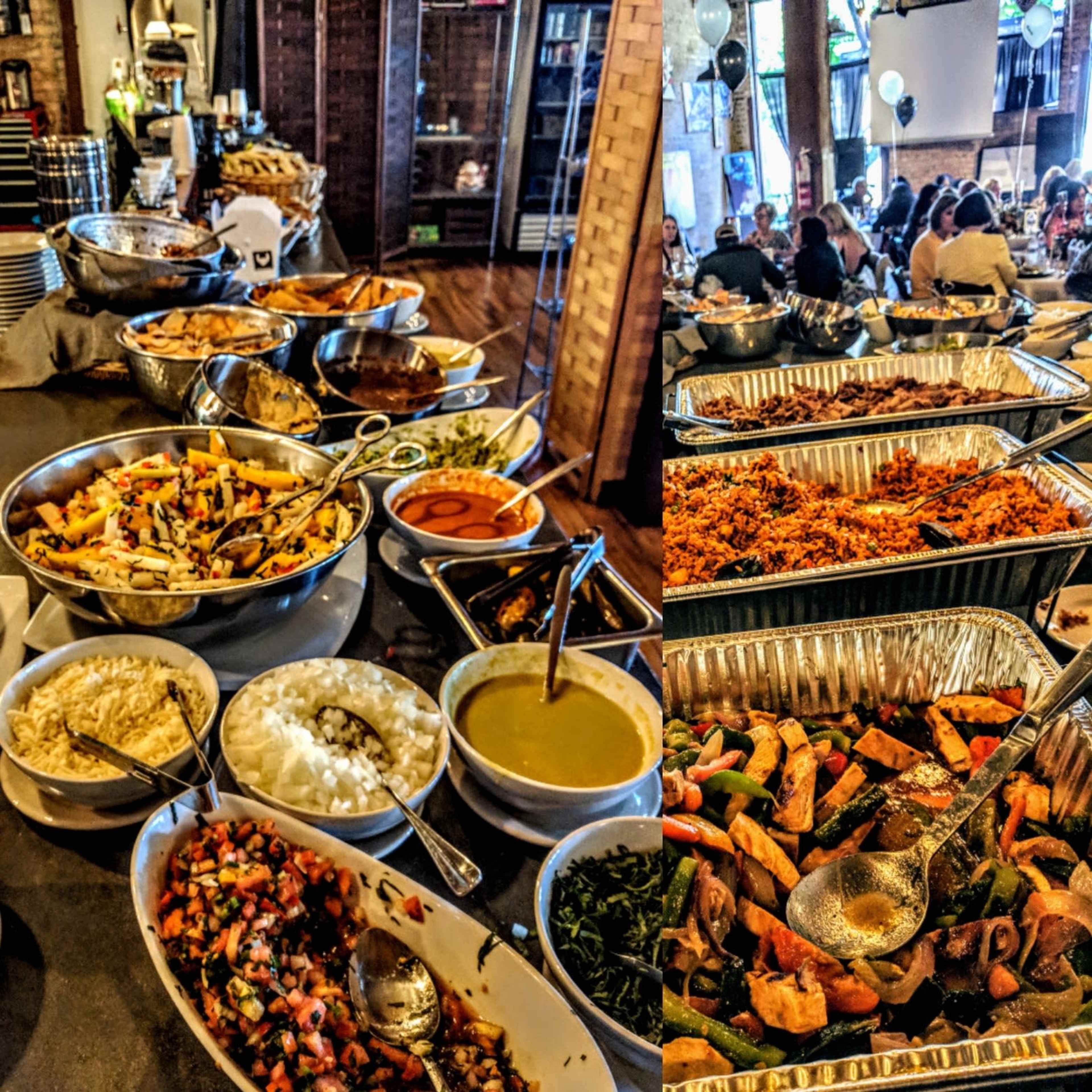 A buffet table displays an array of dishes, including salads, meats, and sides, in metal trays and bowls.