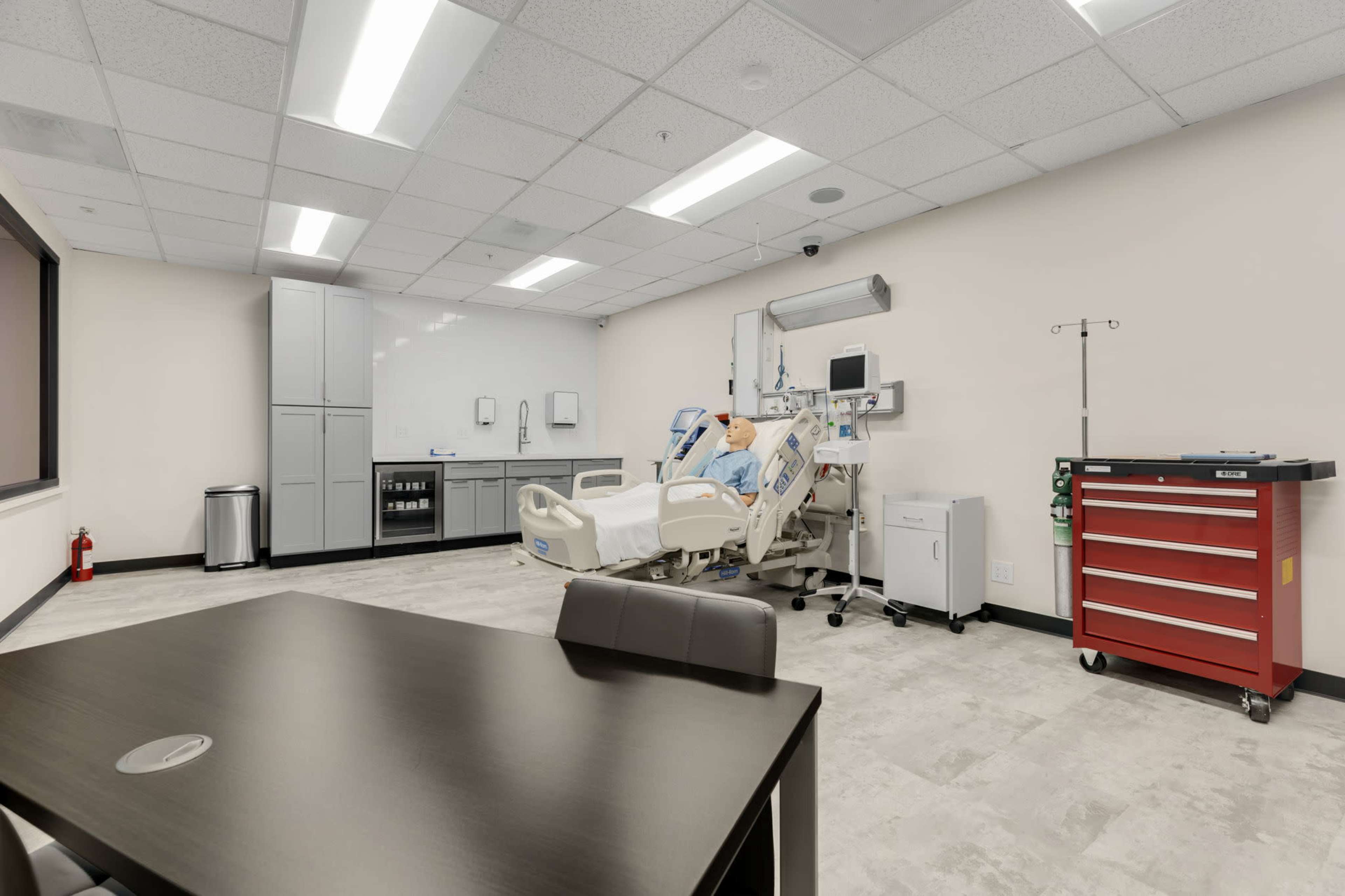 A modern hospital room equipped with a patient bed, medical equipment, and a workstation.