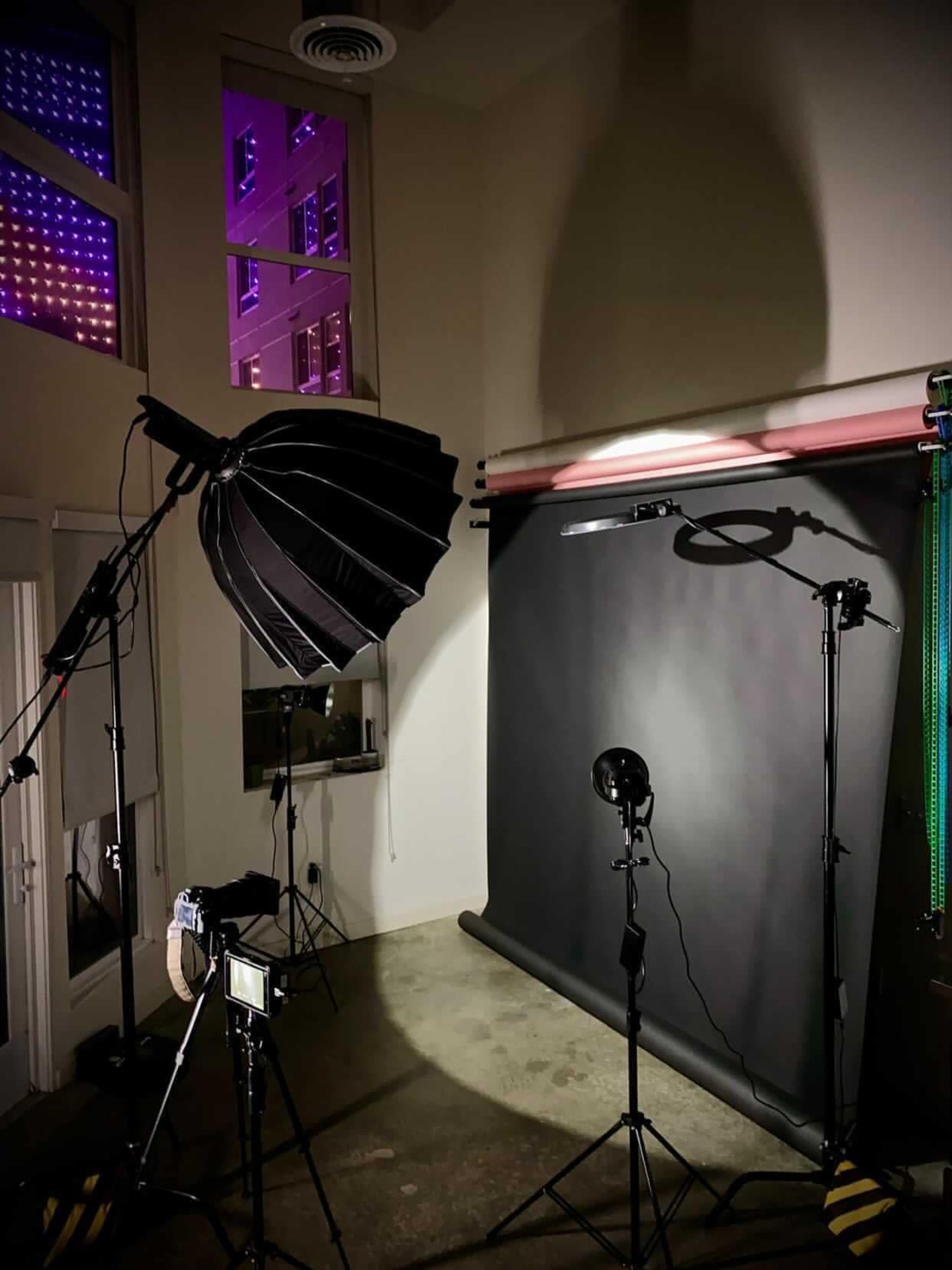 A photography studio setup featuring lighting equipment, a backdrop, and a camera.