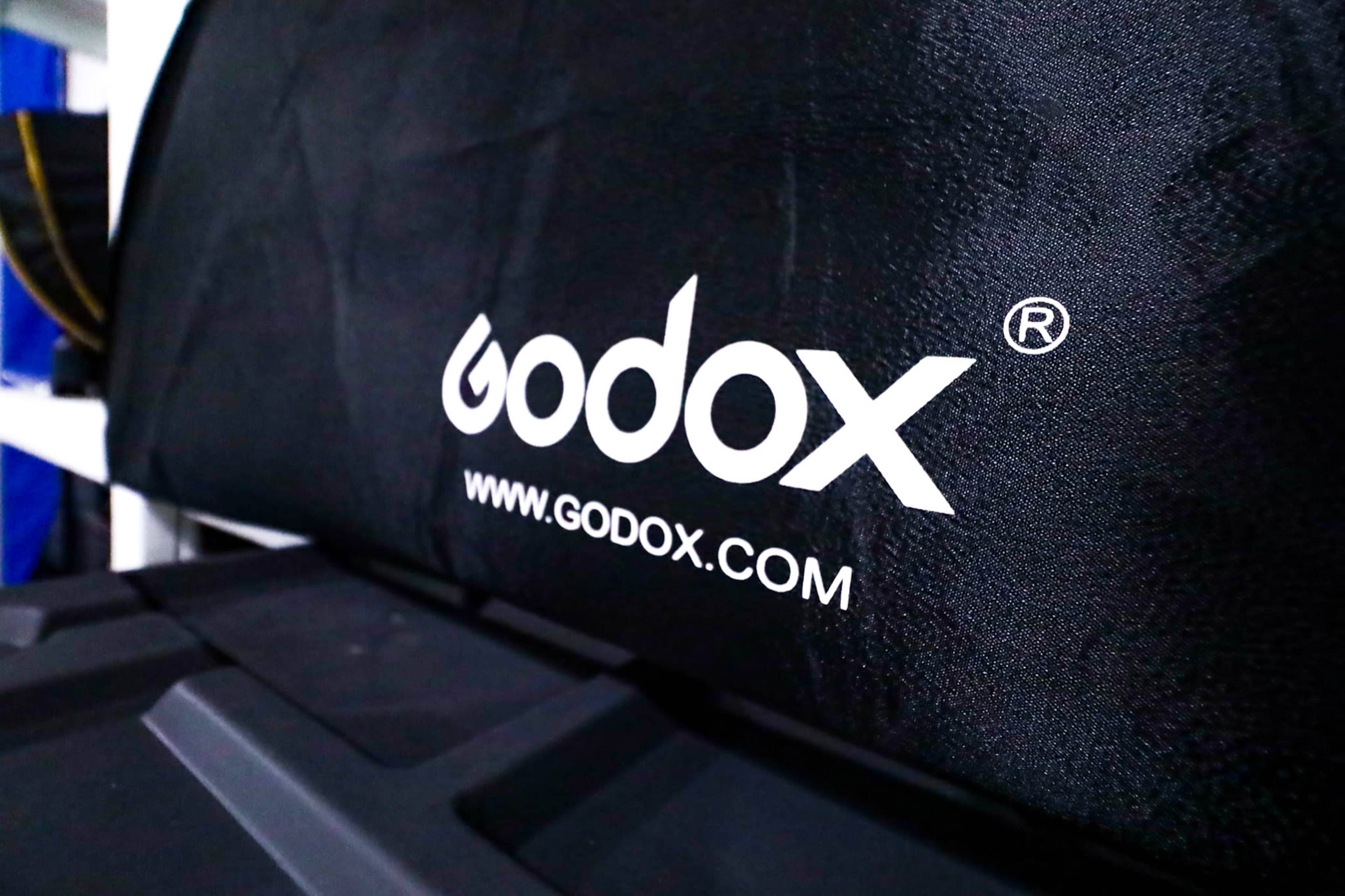 A close-up of a black fabric with the Godox logo and website printed in white.