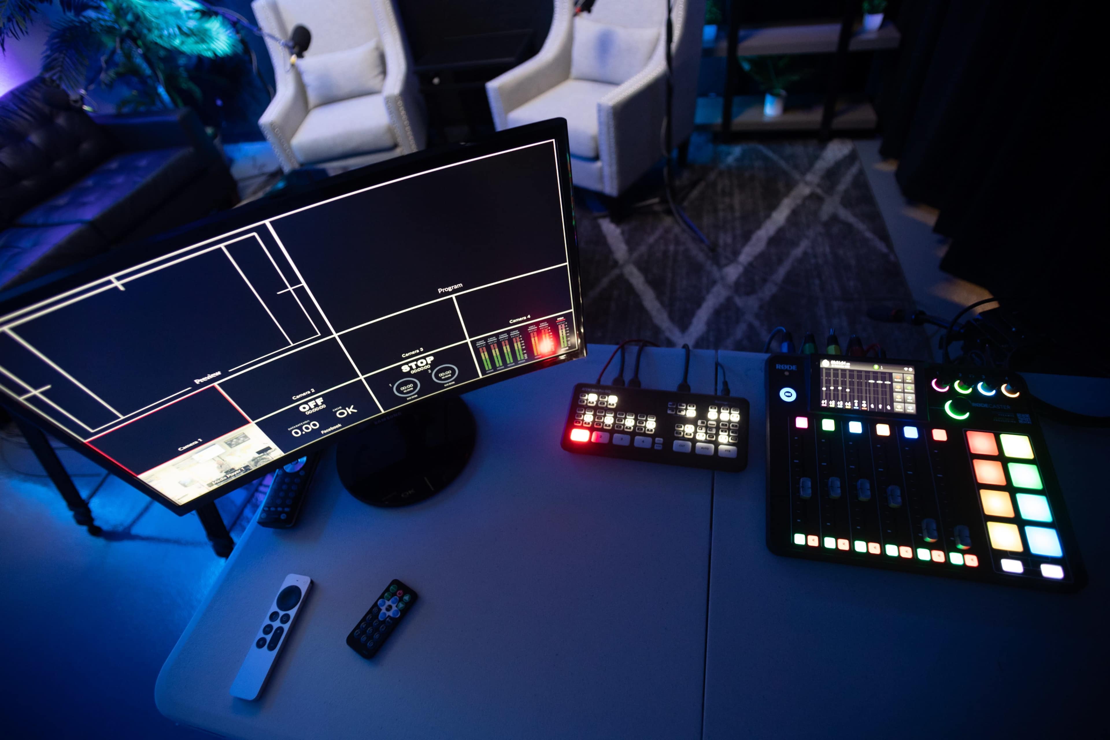 A production or editing setup with a monitor displaying a grid interface and a control panel featuring various buttons and sliders.