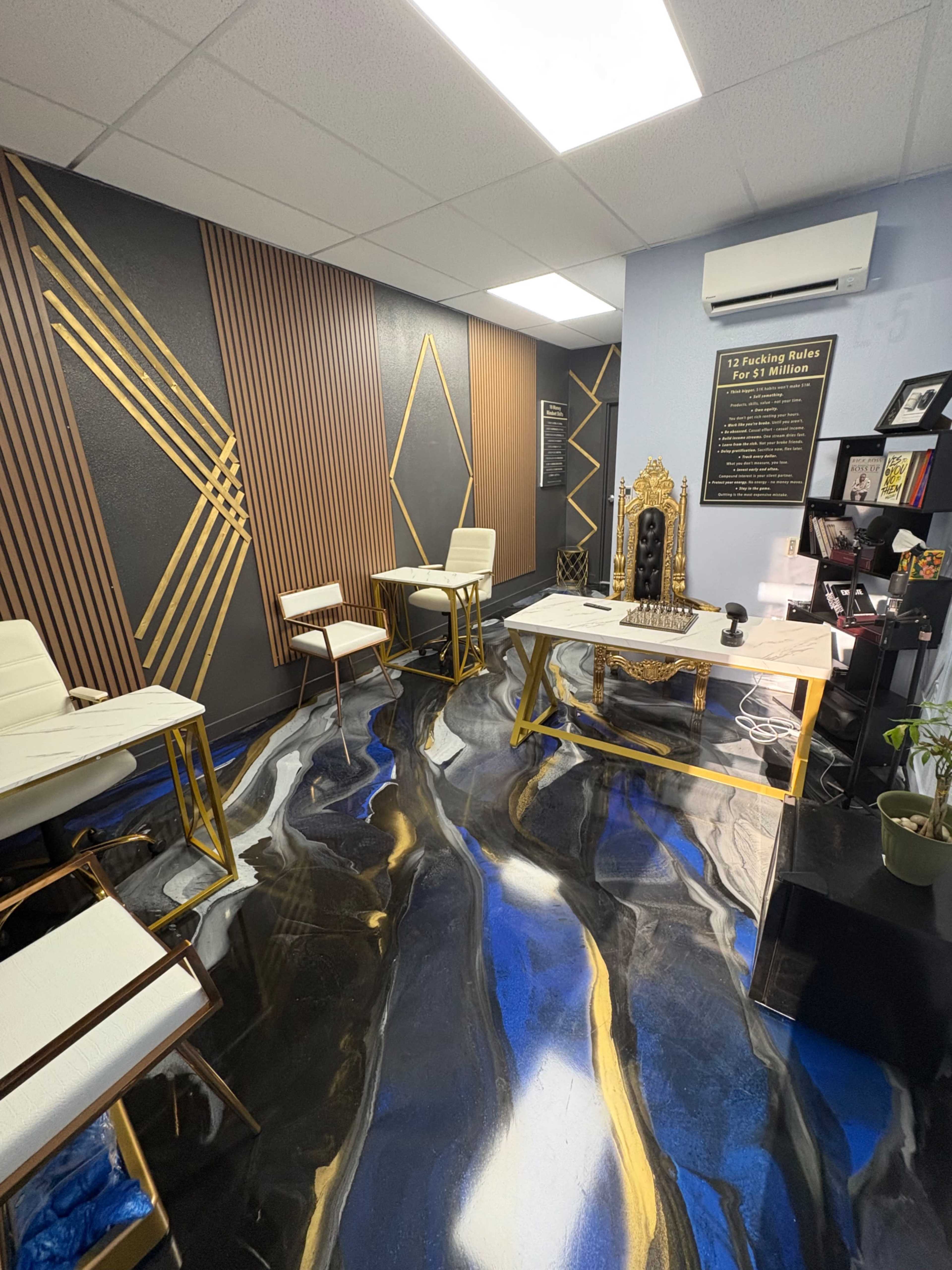 The image shows a modern office space featuring a glossy, abstract floor, stylish white chairs, and decorative wall panels with geometric designs.