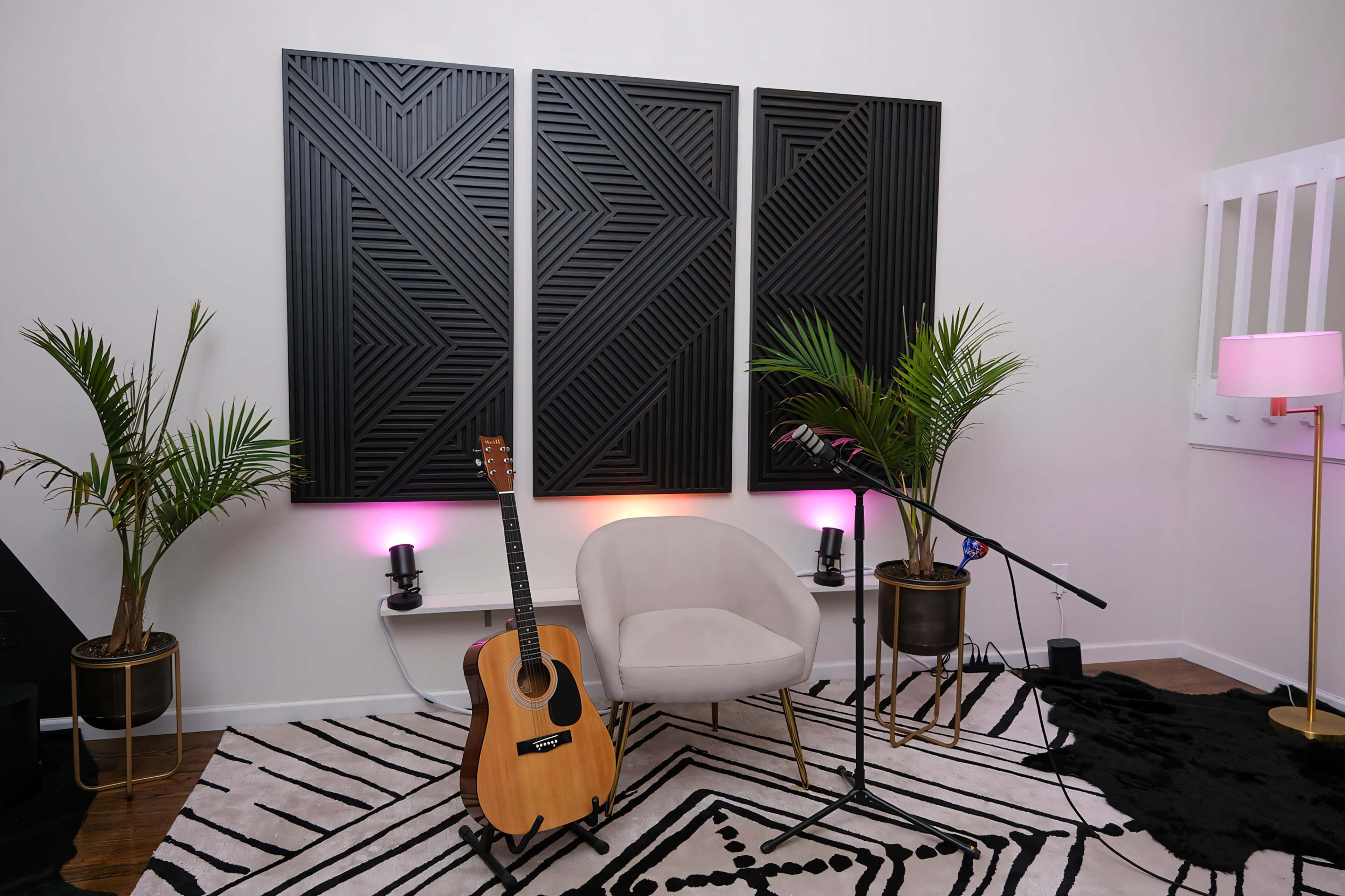 A cozy music setup featuring an acoustic guitar leaning against a modern chair, with geometric wall panels and plants in the background.