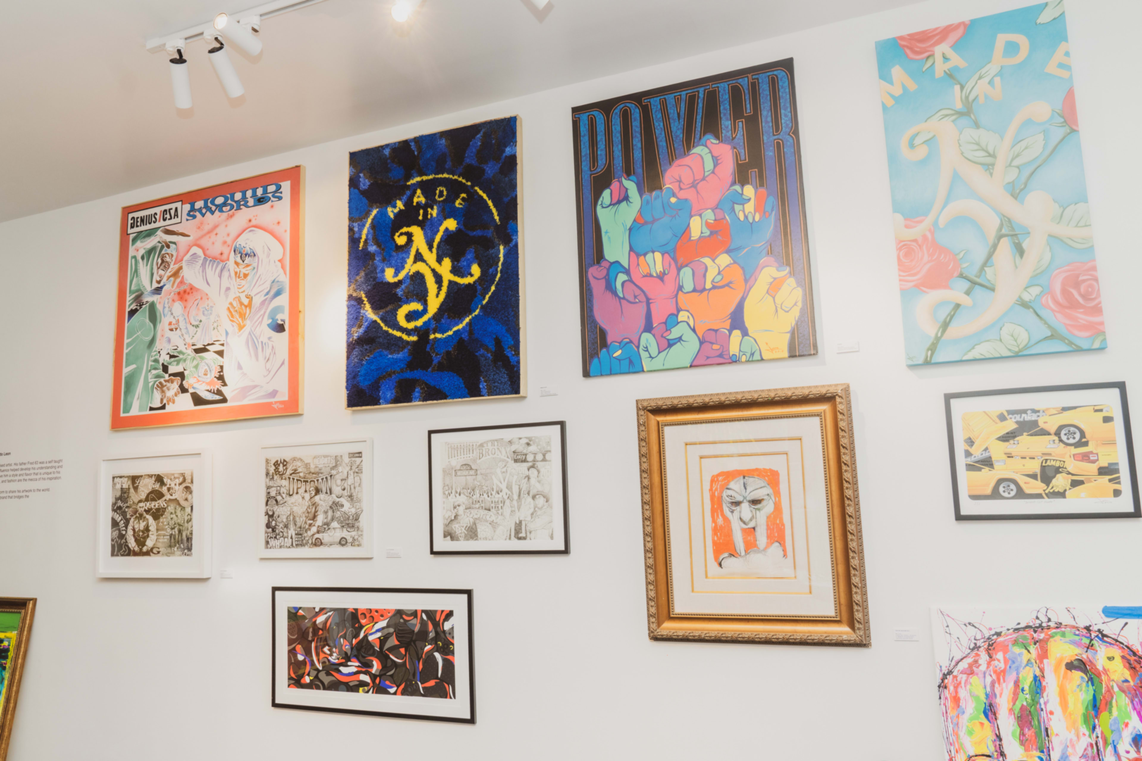 A gallery wall displaying a collection of various framed artworks, including colorful posters and illustrations.