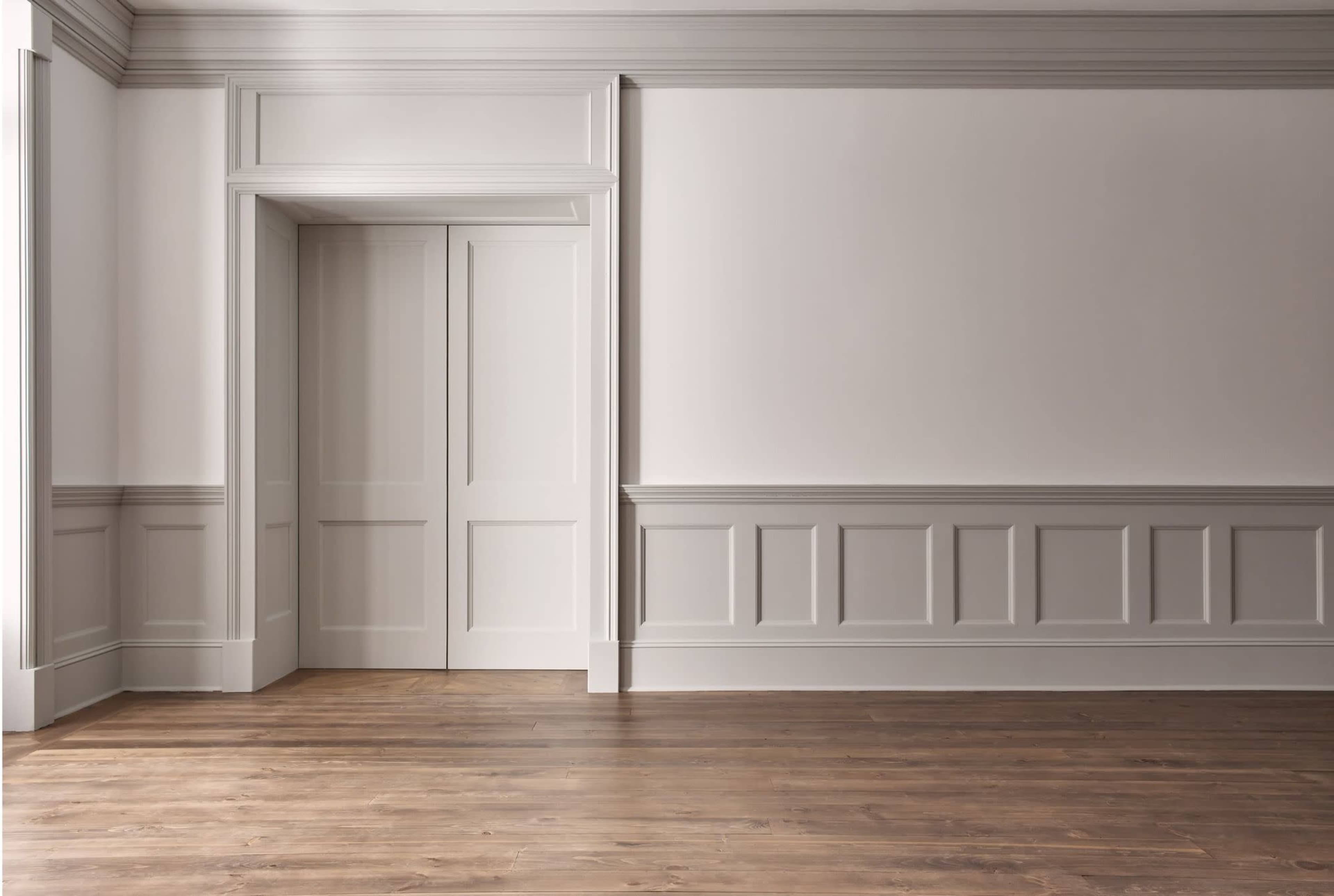The image shows a spacious, minimalist interior with light-colored walls, a wooden floor, and a doorway on the left.
