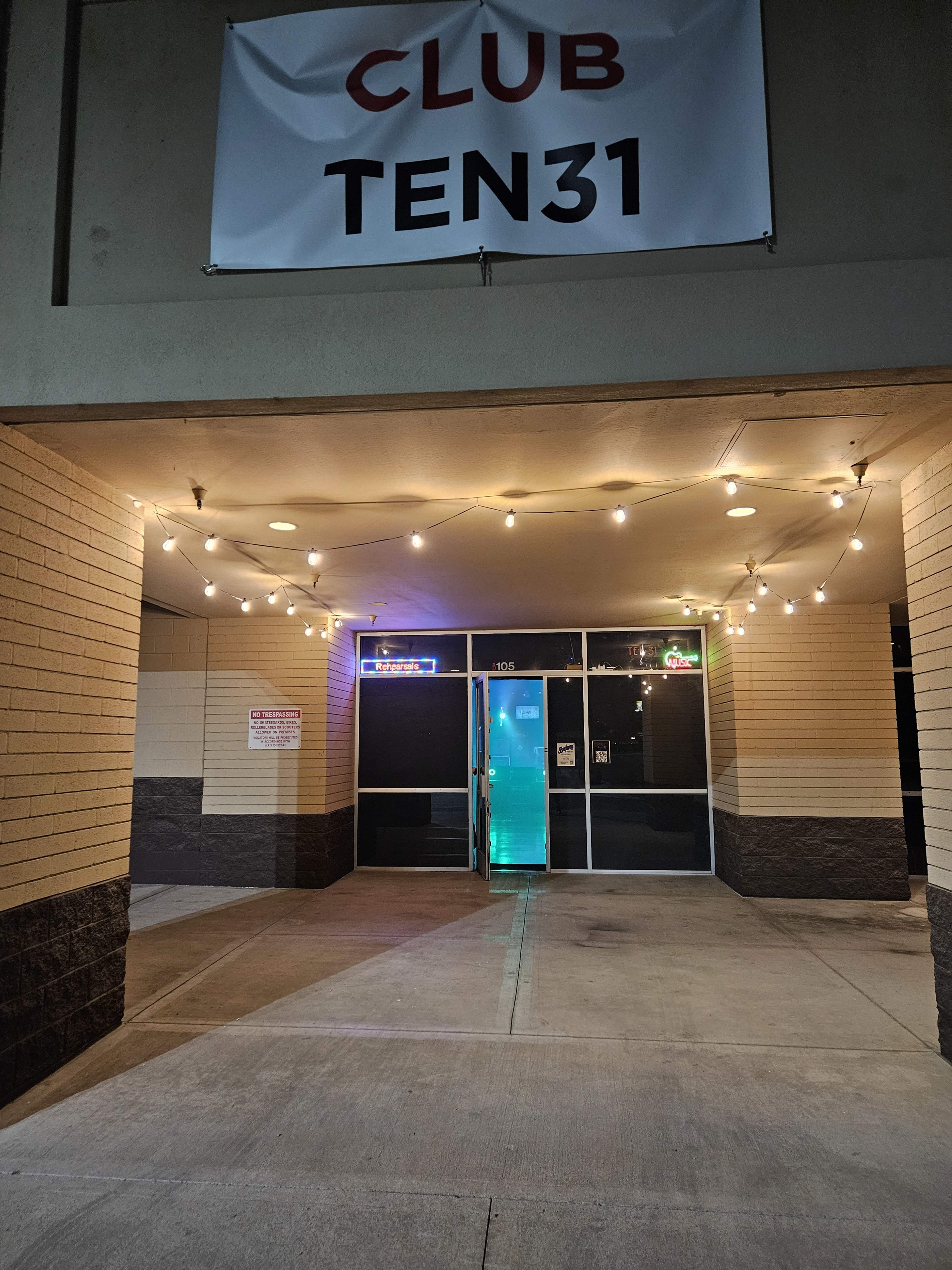 The image shows the entrance of Club Ten31, featuring a lit doorway and string lights overhead.