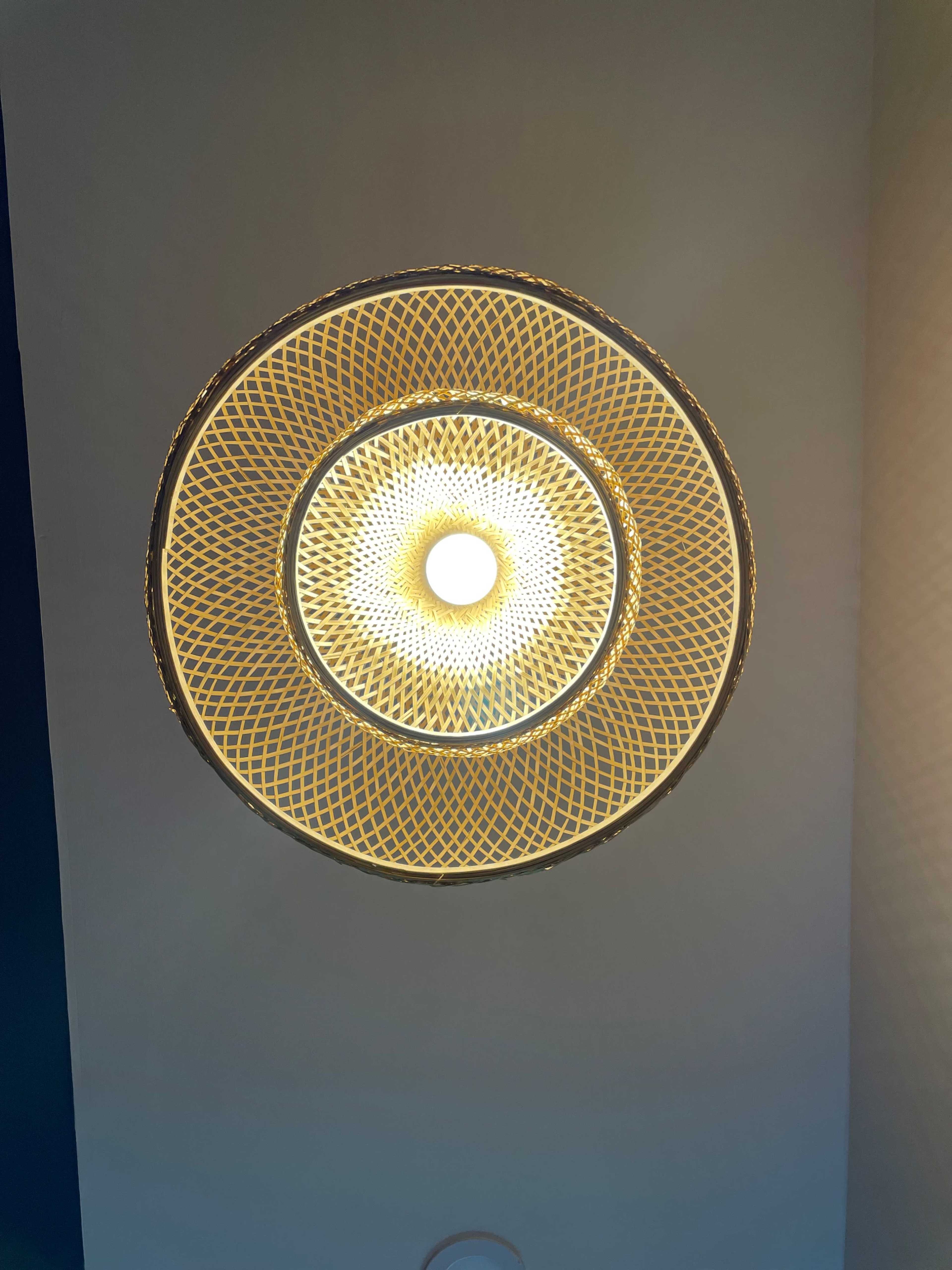A circular ceiling light fixture with a geometric woven design and a central bulb.