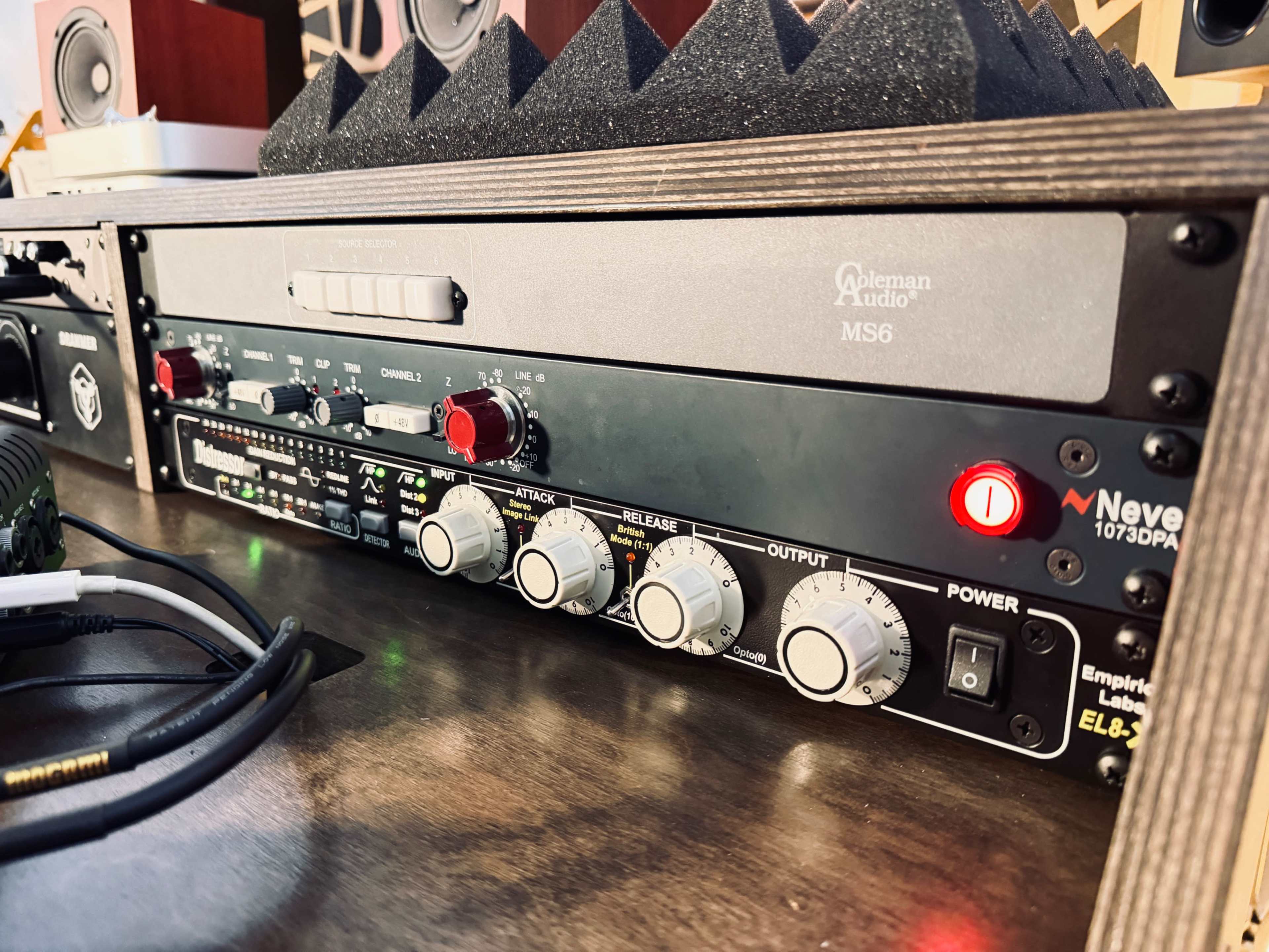 The image shows a close-up of a professional audio equipment rack featuring a Neve 1073DPA preamp and a Coleman Audio MS6 monitor controller.