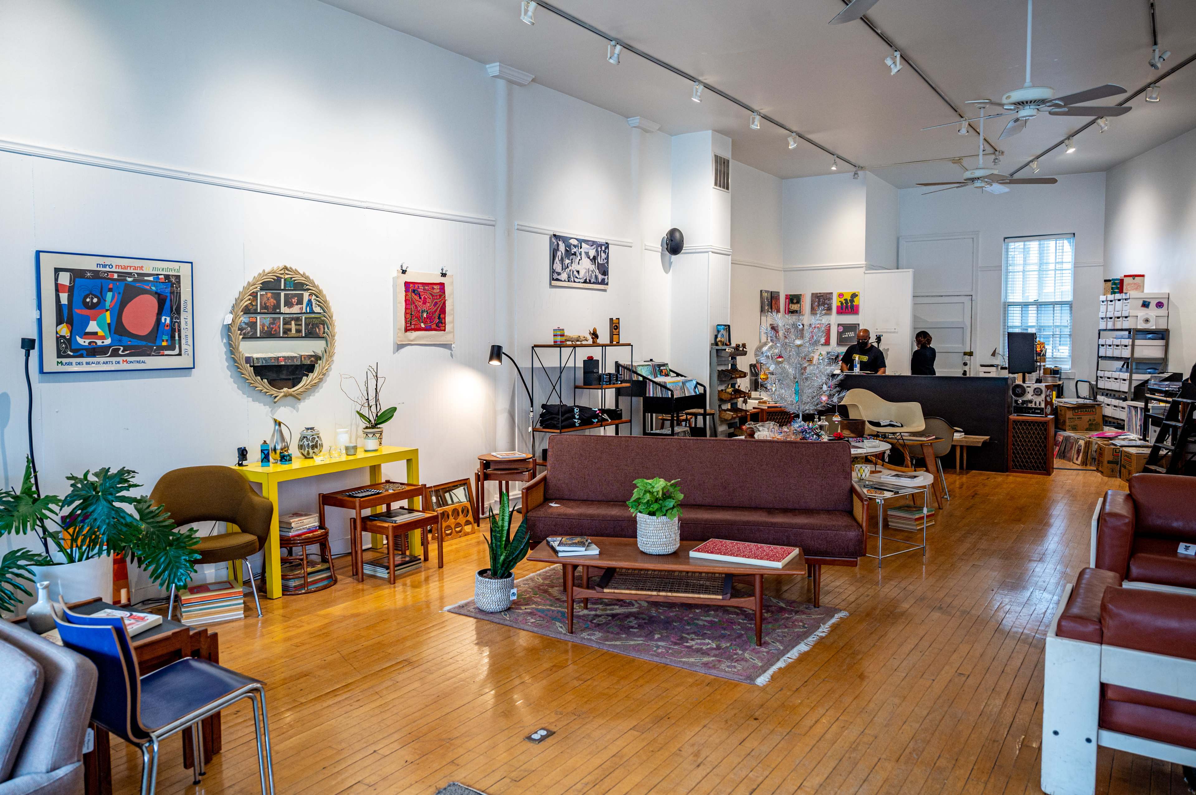 A spacious indoor area with a mix of seating arrangements, artworks on the walls, and a bright, inviting atmosphere.