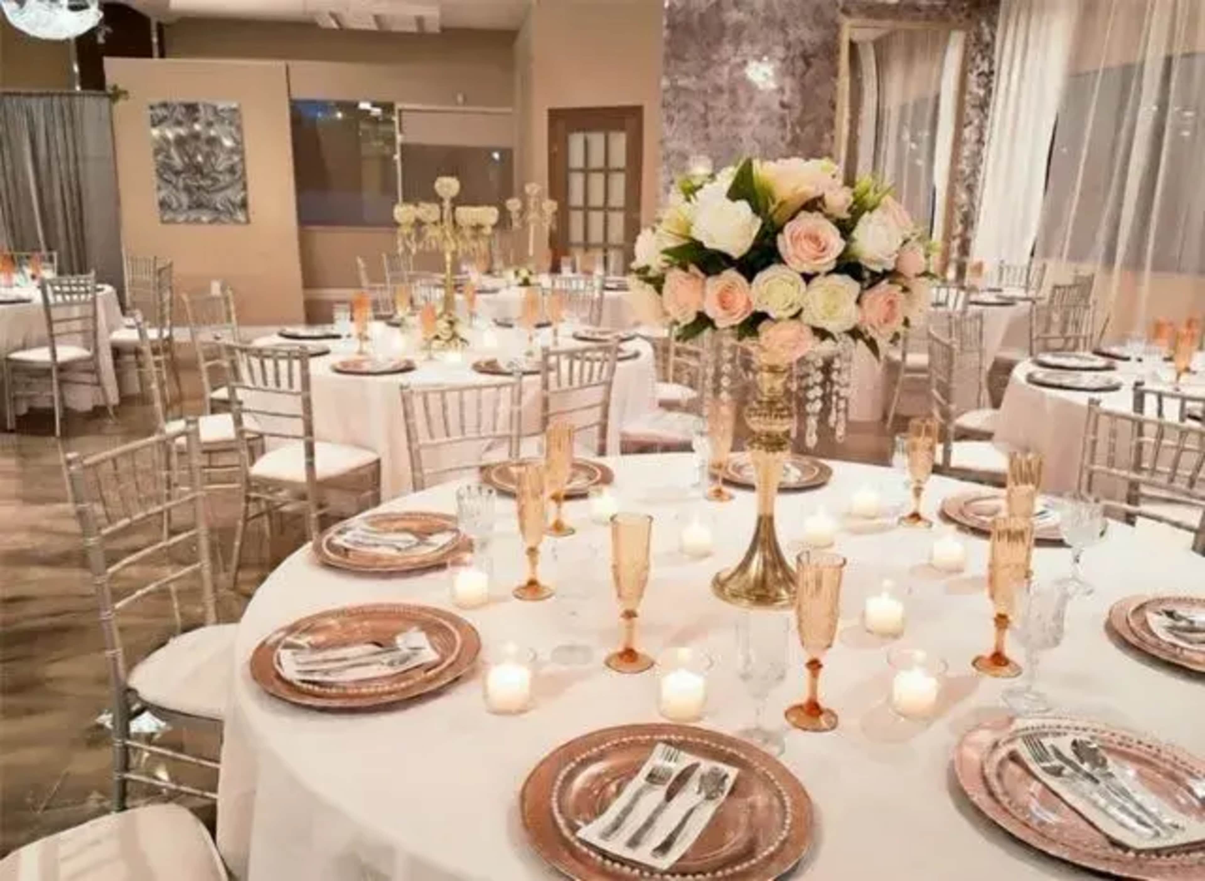 The image shows a beautifully arranged dining area with round tables, elegant decorations, and floral centerpieces.