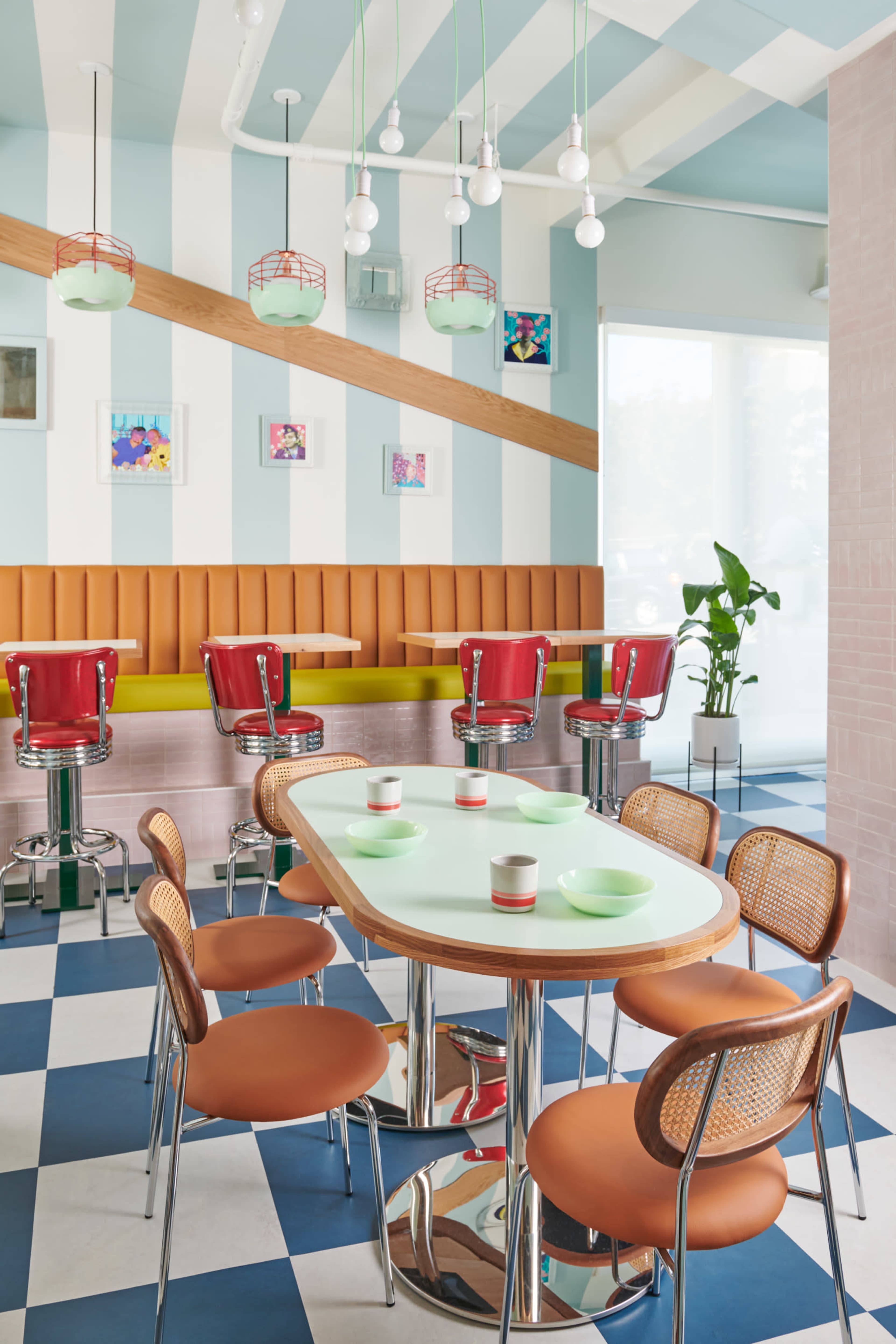 A brightly decorated café with colorful seating, checkered flooring, and modern light fixtures.