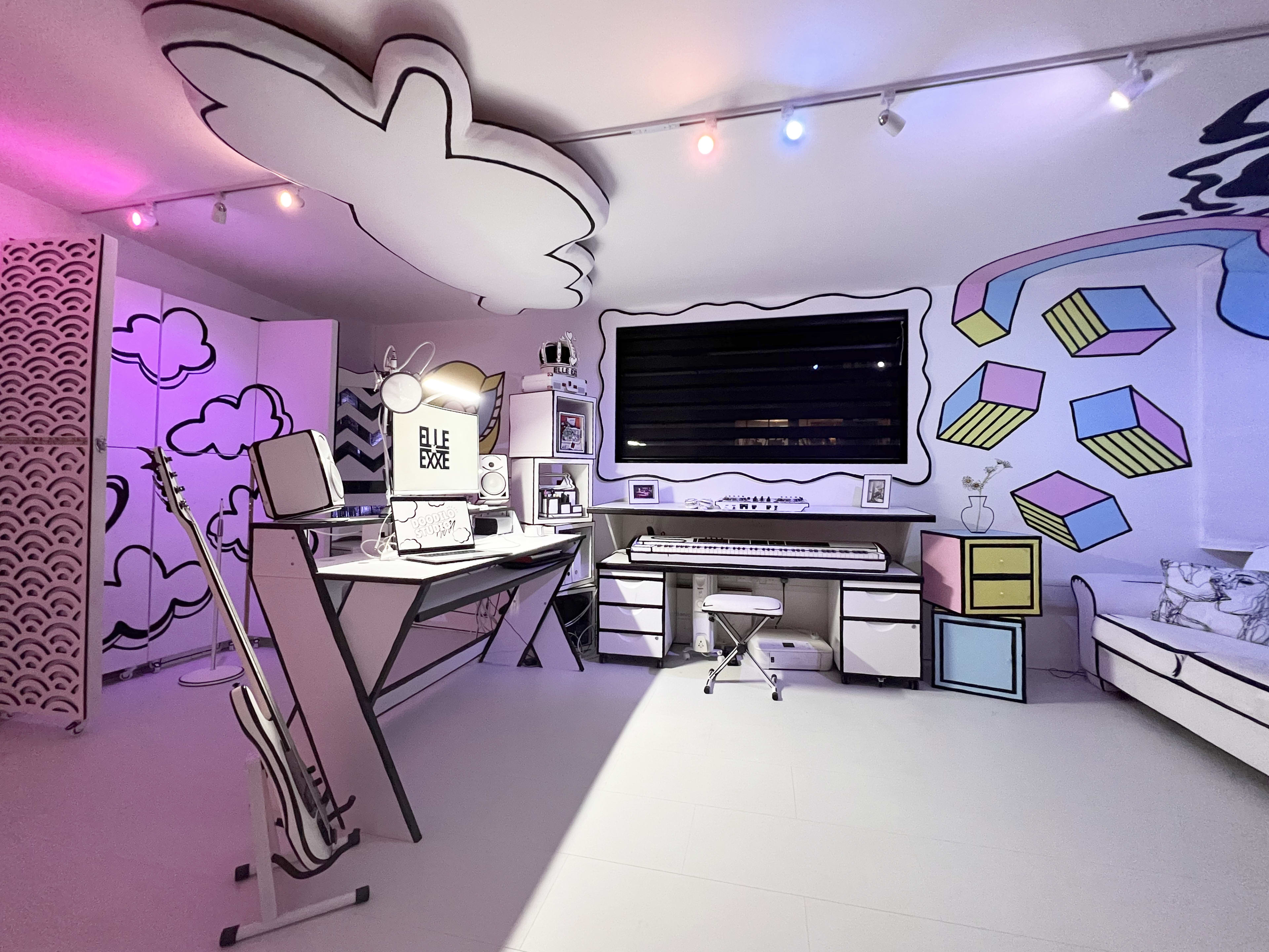 A vibrant, cartoon-inspired room with a desk, keyboard, and decorative elements on the walls, including clouds and geometric shapes.